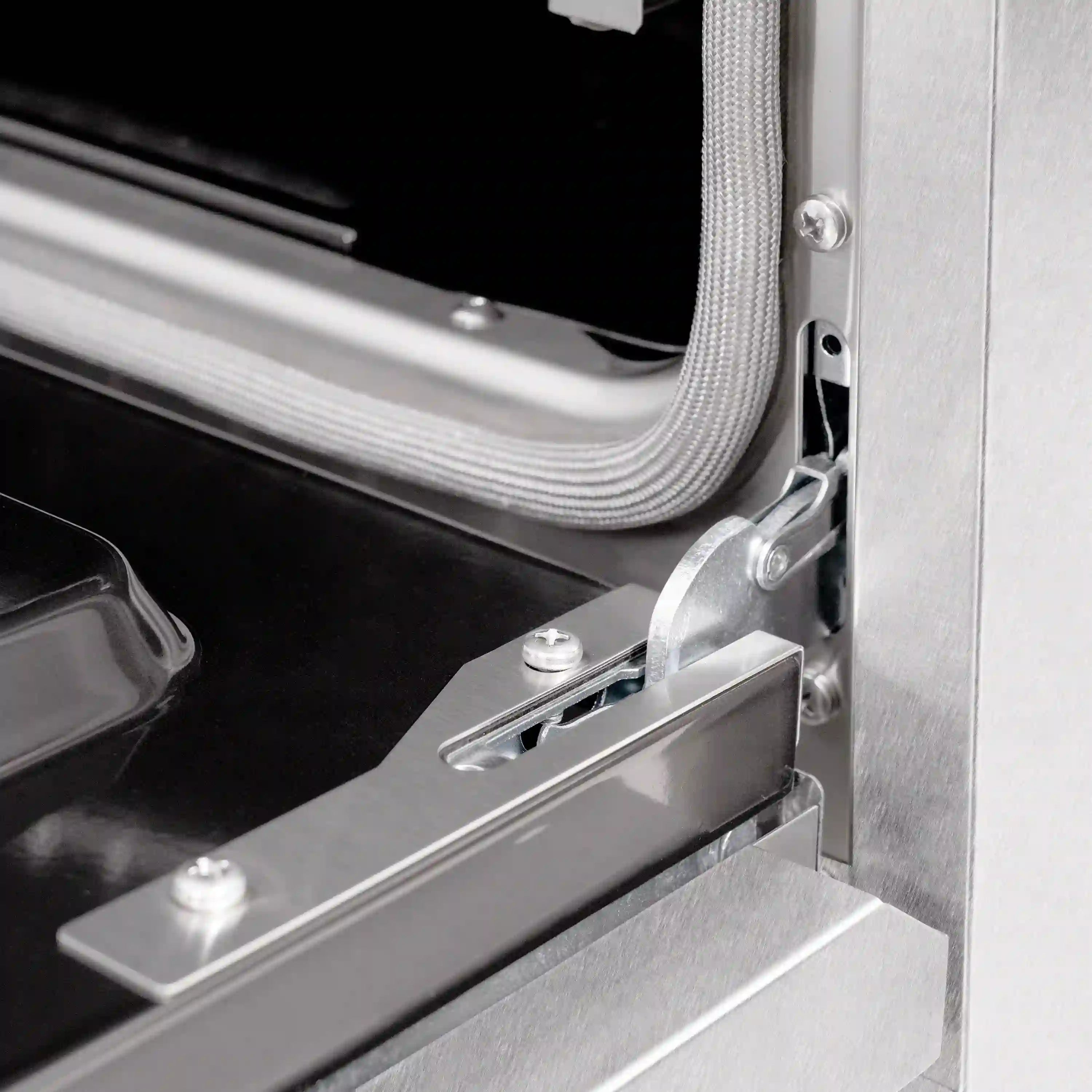 Satin stainless steel gas range side panel with gold-trimmed door latch detail
