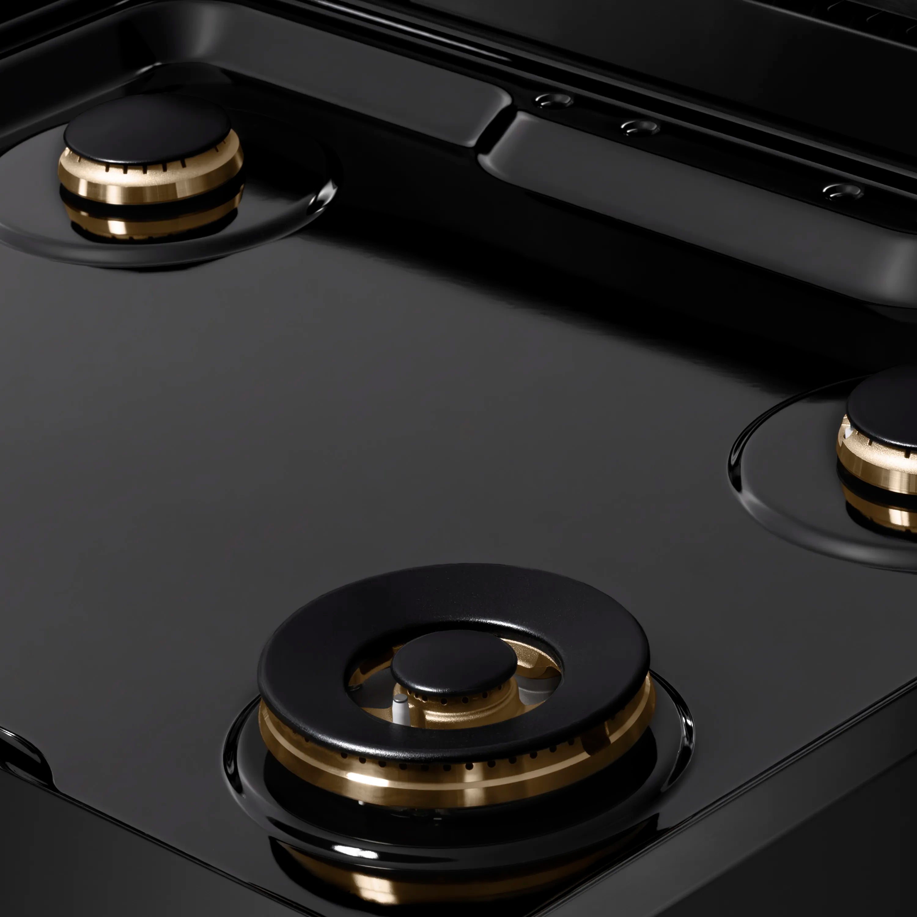 Black gas burner cap with gold ring detail on a porcelain rangetop