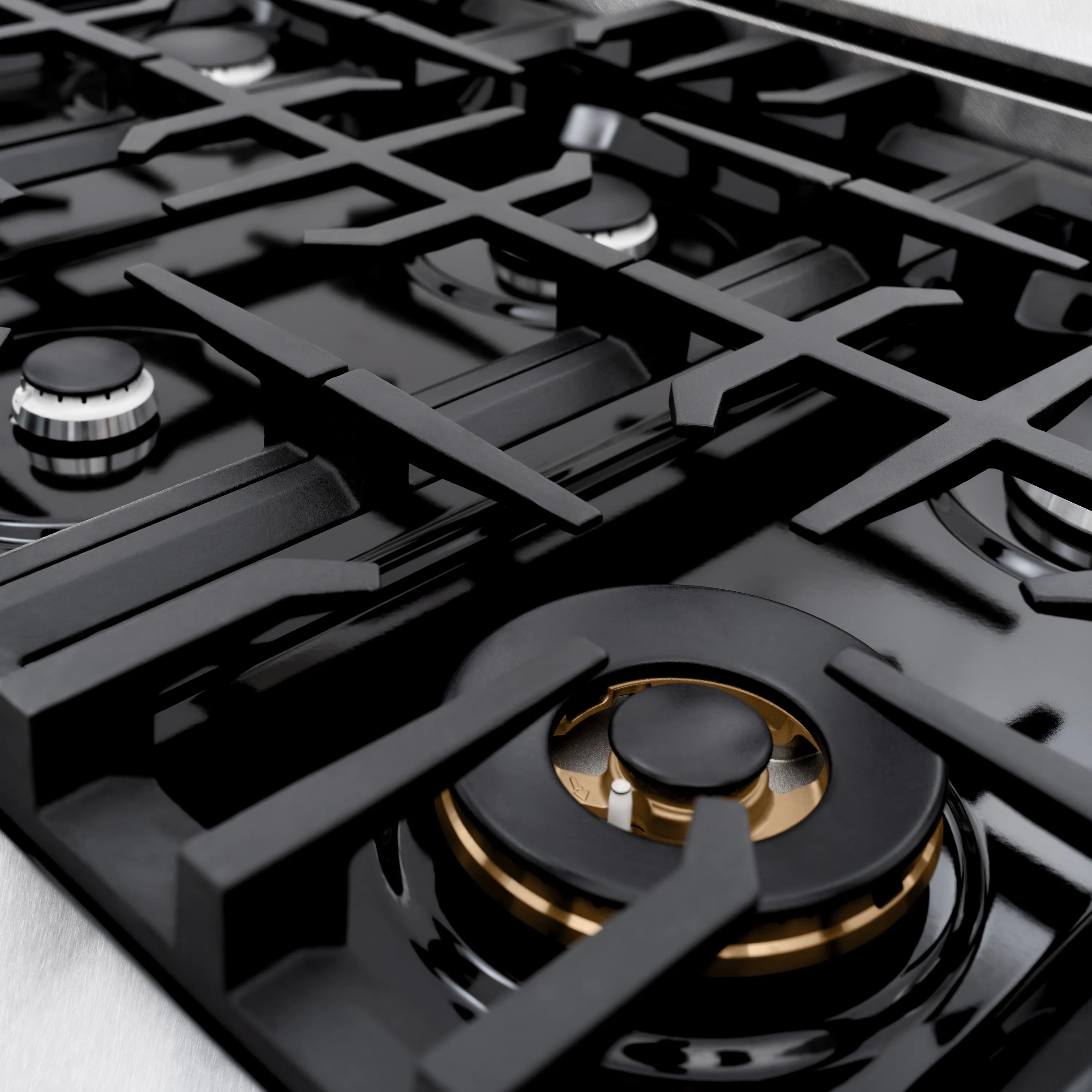 Gas burner grates and black control knob on a black cooktop surface