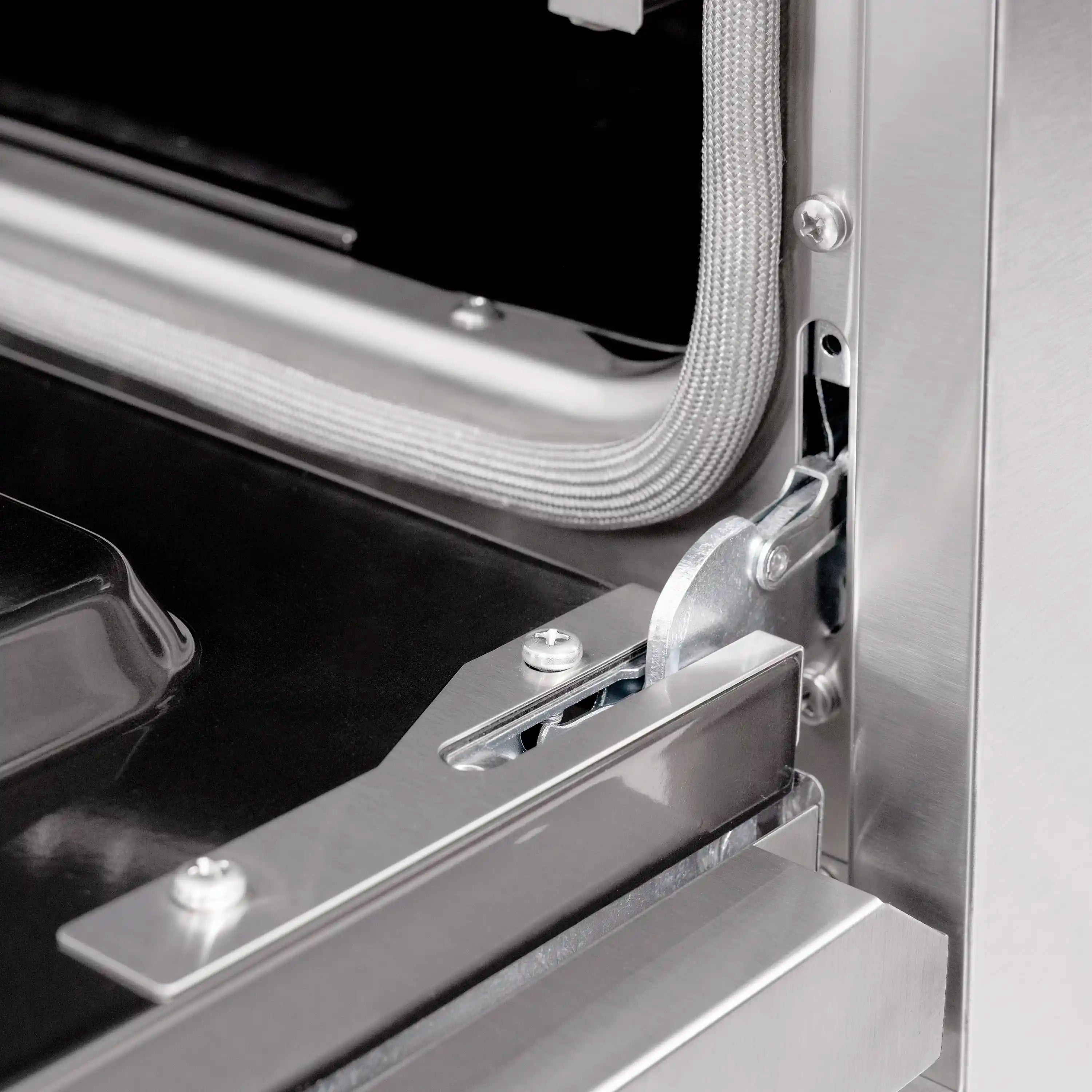 Stainless steel gas range oven door hinge and mounting bracket detail