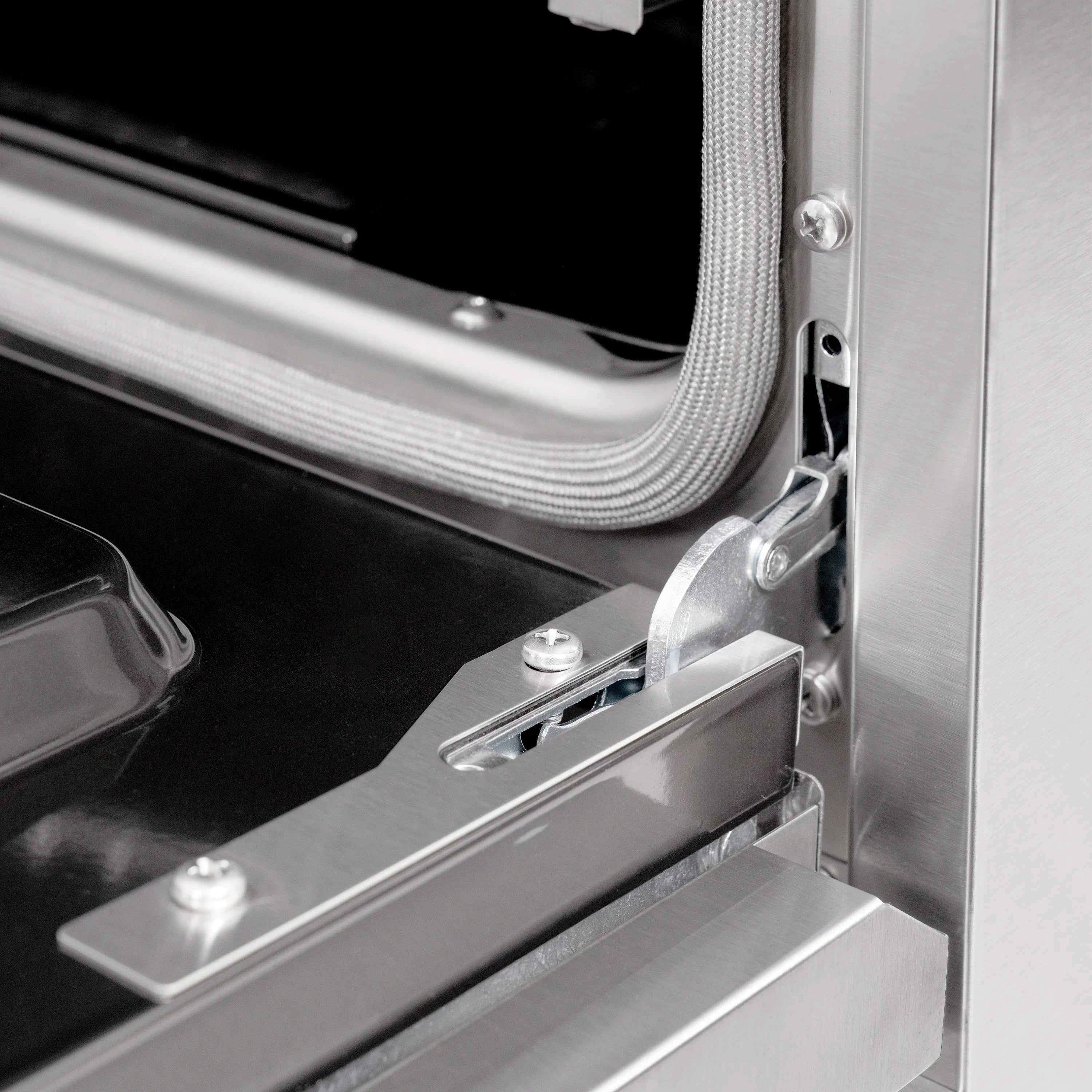 Gas range oven door hinge area with stainless steel frame and black interior floor