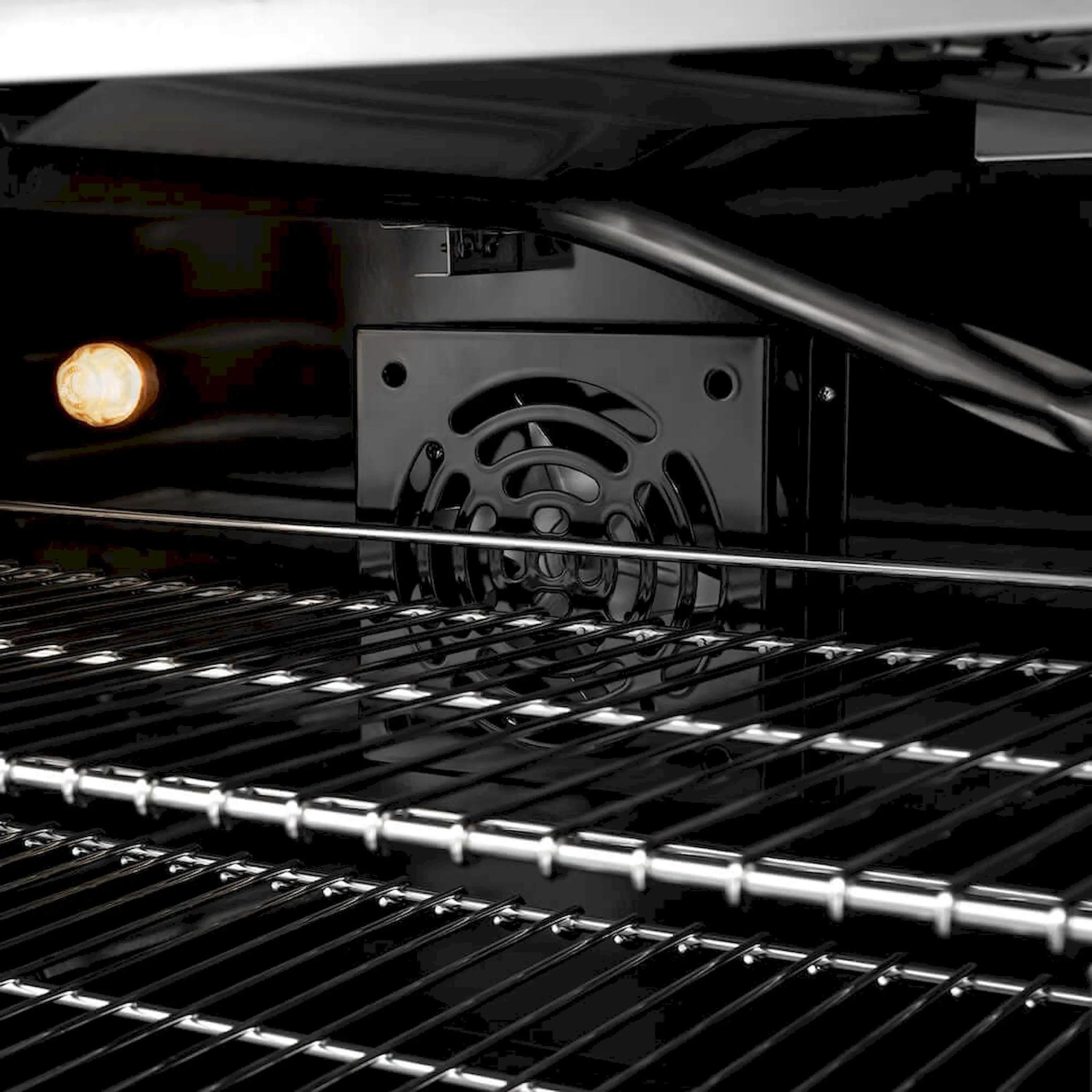 Gas range oven interior with glowing burner and black enamel grates