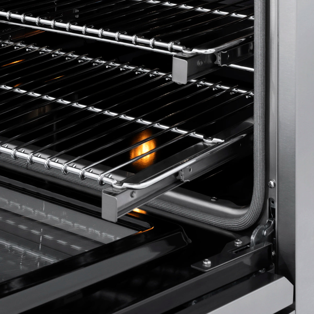 Black dual fuel cooktop grates with bronze burner flame glow visible in back