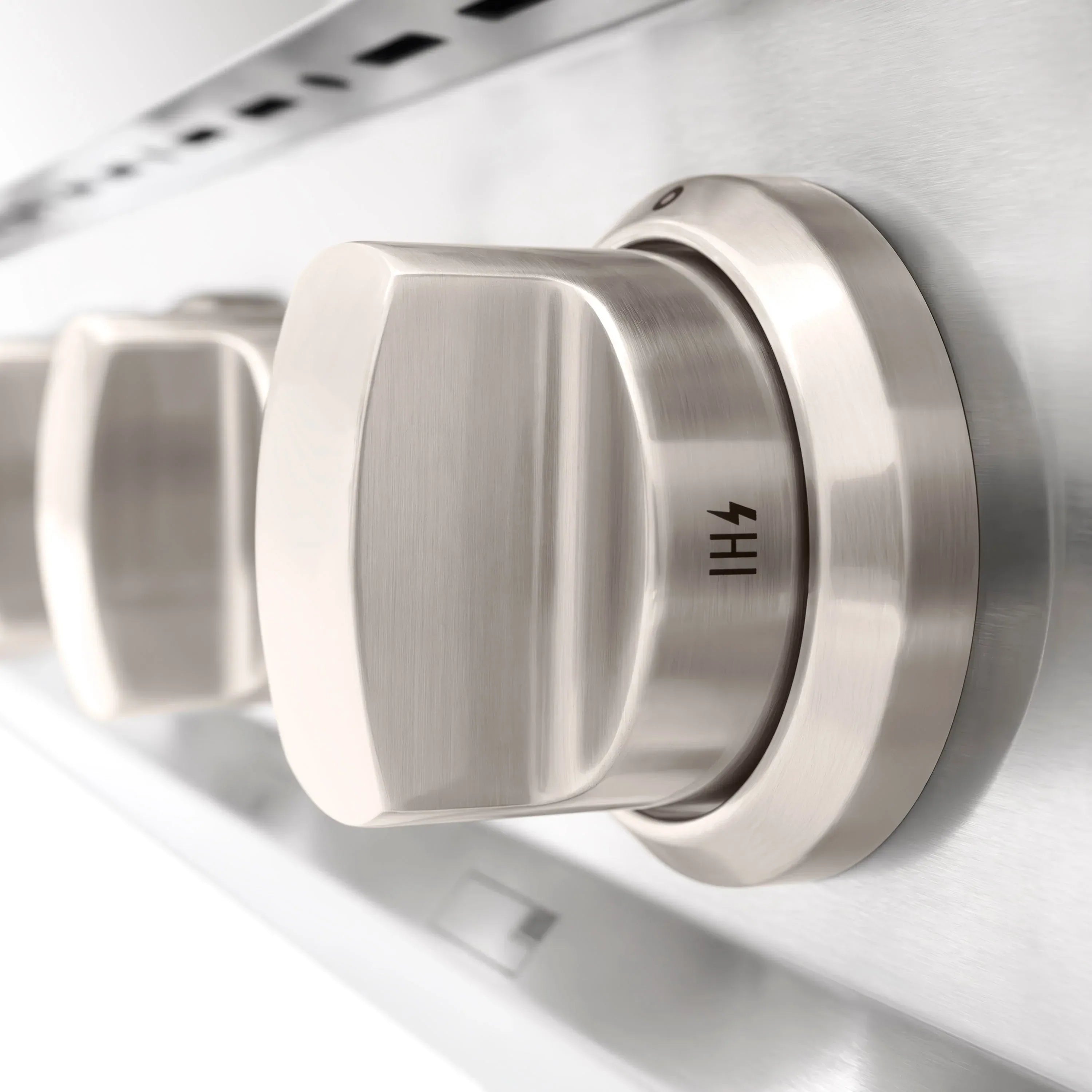 Stainless steel control knob with tapered ring on a brushed gas cooktop