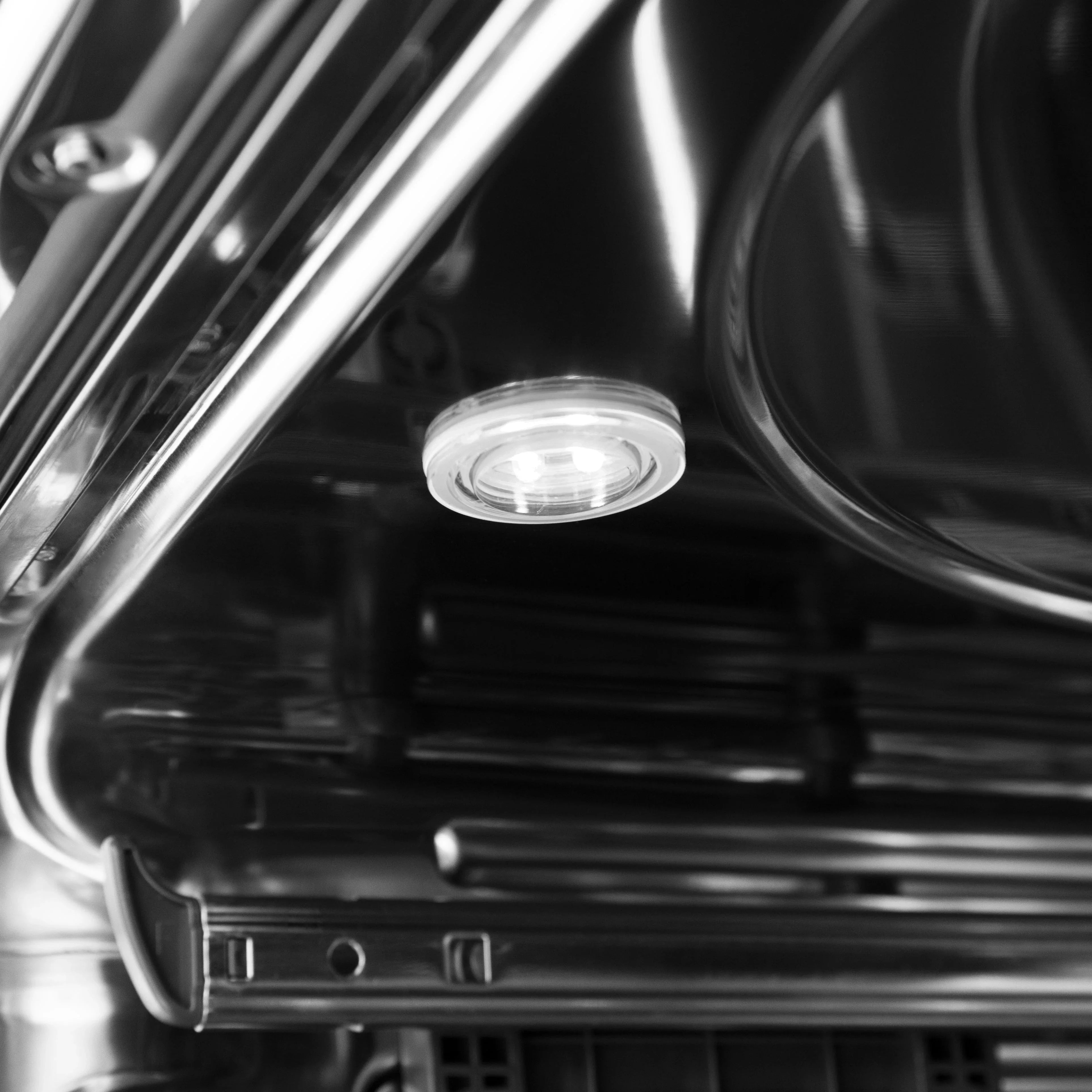 Stainless dishwasher wash tub close-up with circular drain cover detail