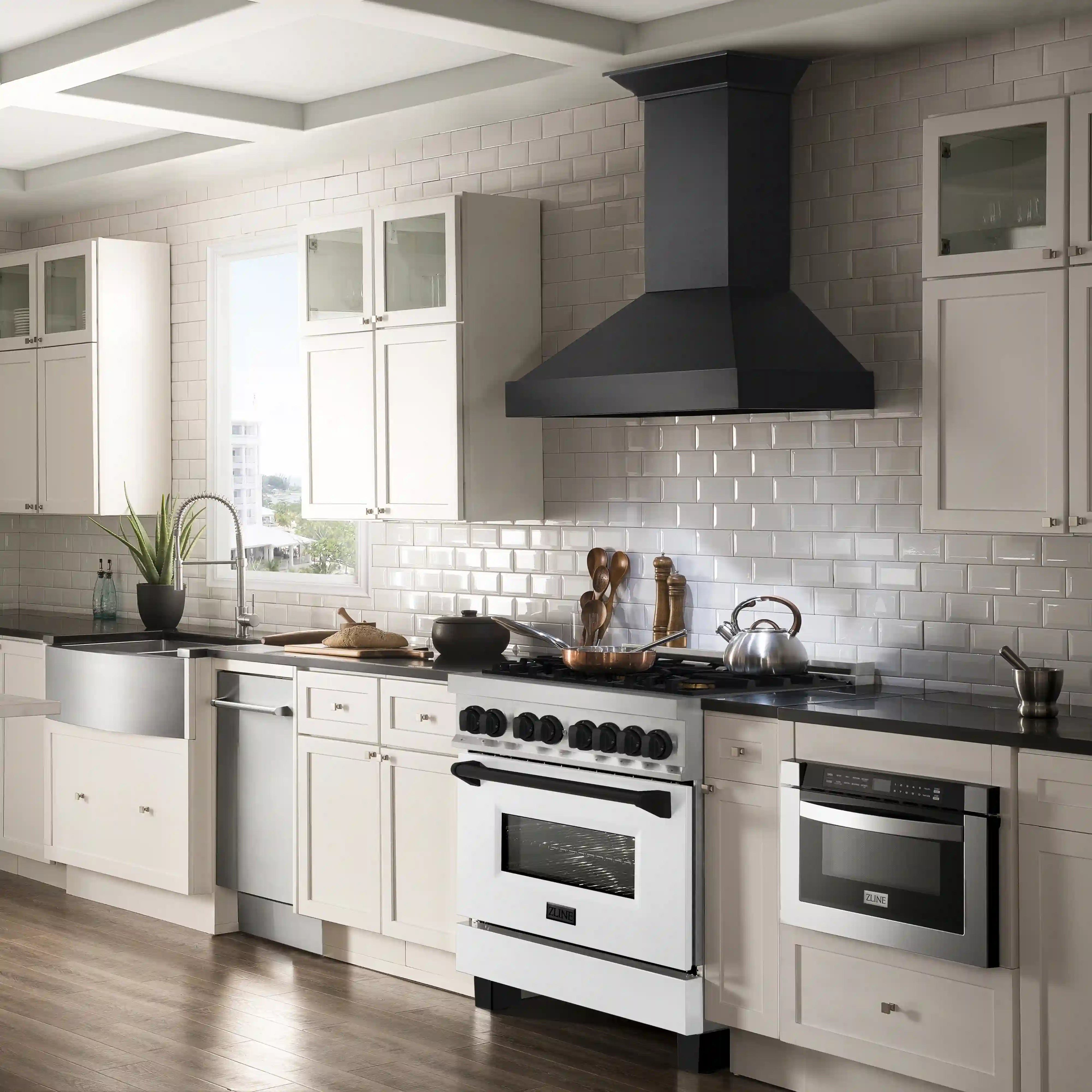 Dual-fuel range in a kitchen with white cabinetry, black hood, and cooktop burners