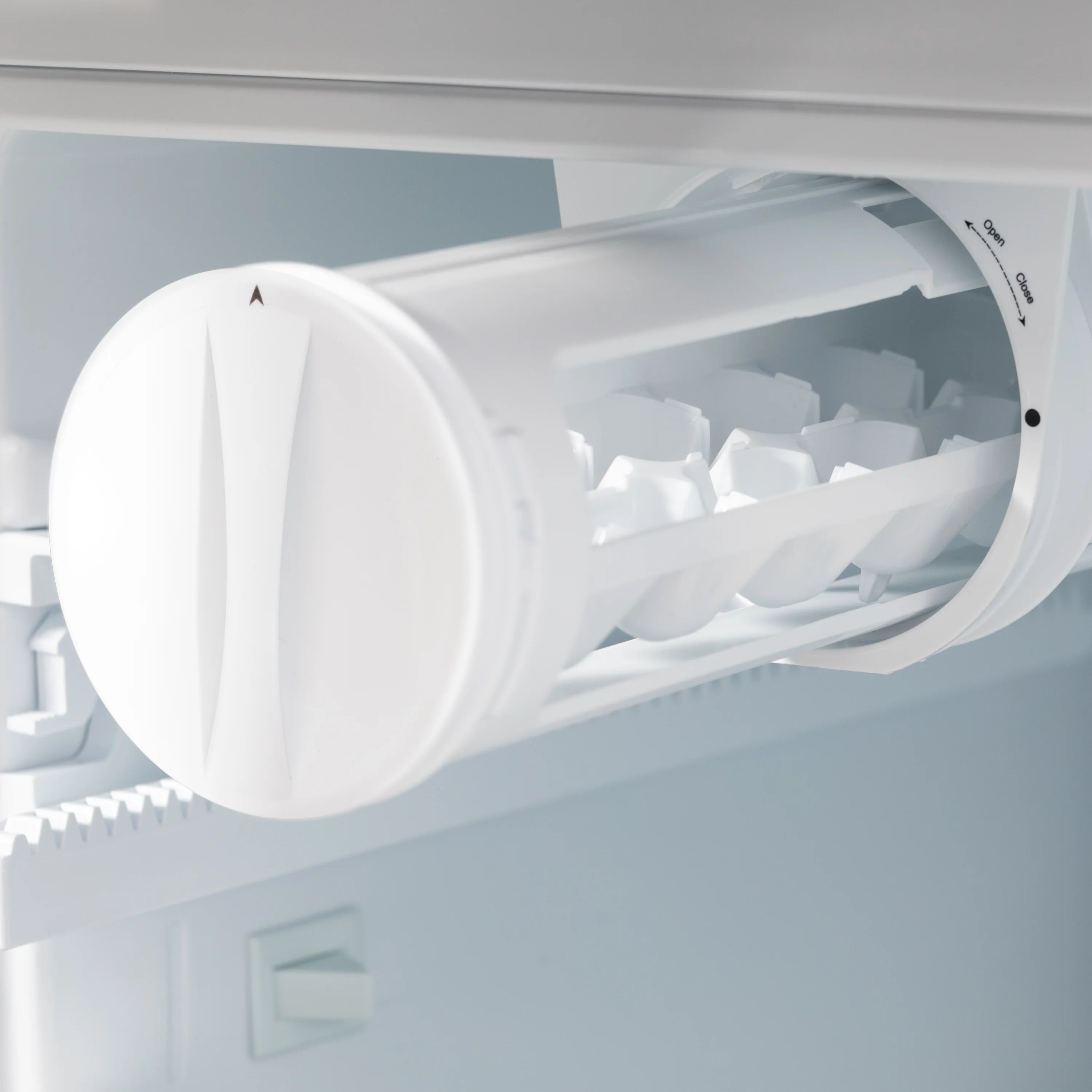 Refrigerator ice maker chute and dispensing chute detail inside the freezer