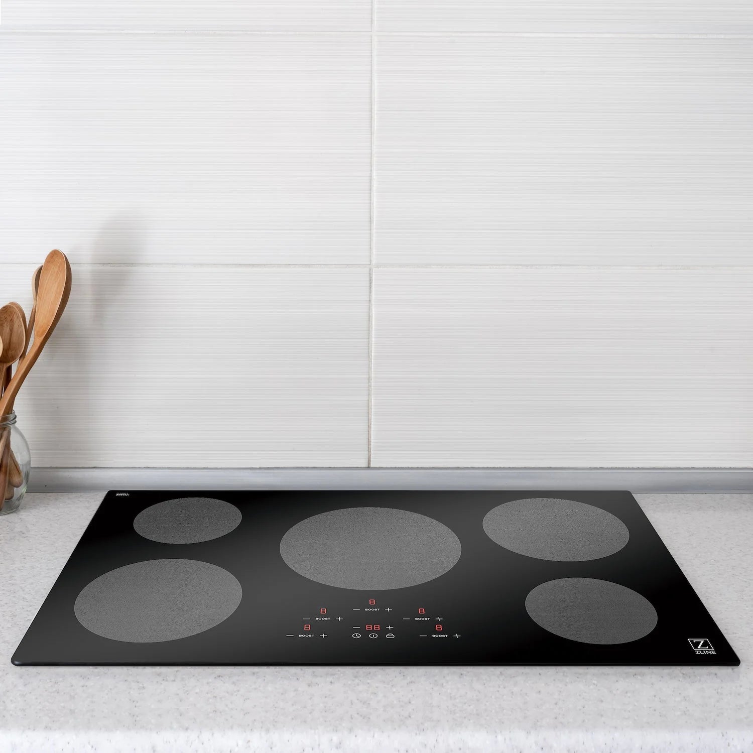 Black glass induction cooktop with five gray circular burner zones and control panel