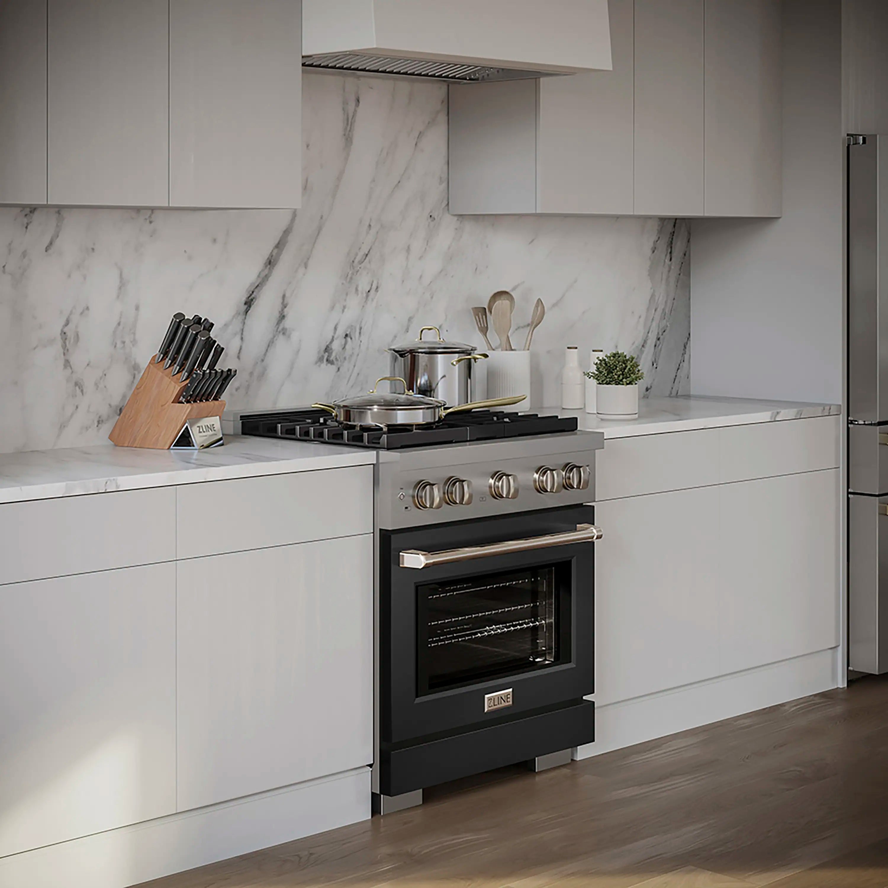 Black range with brass control knobs and open cooktop area