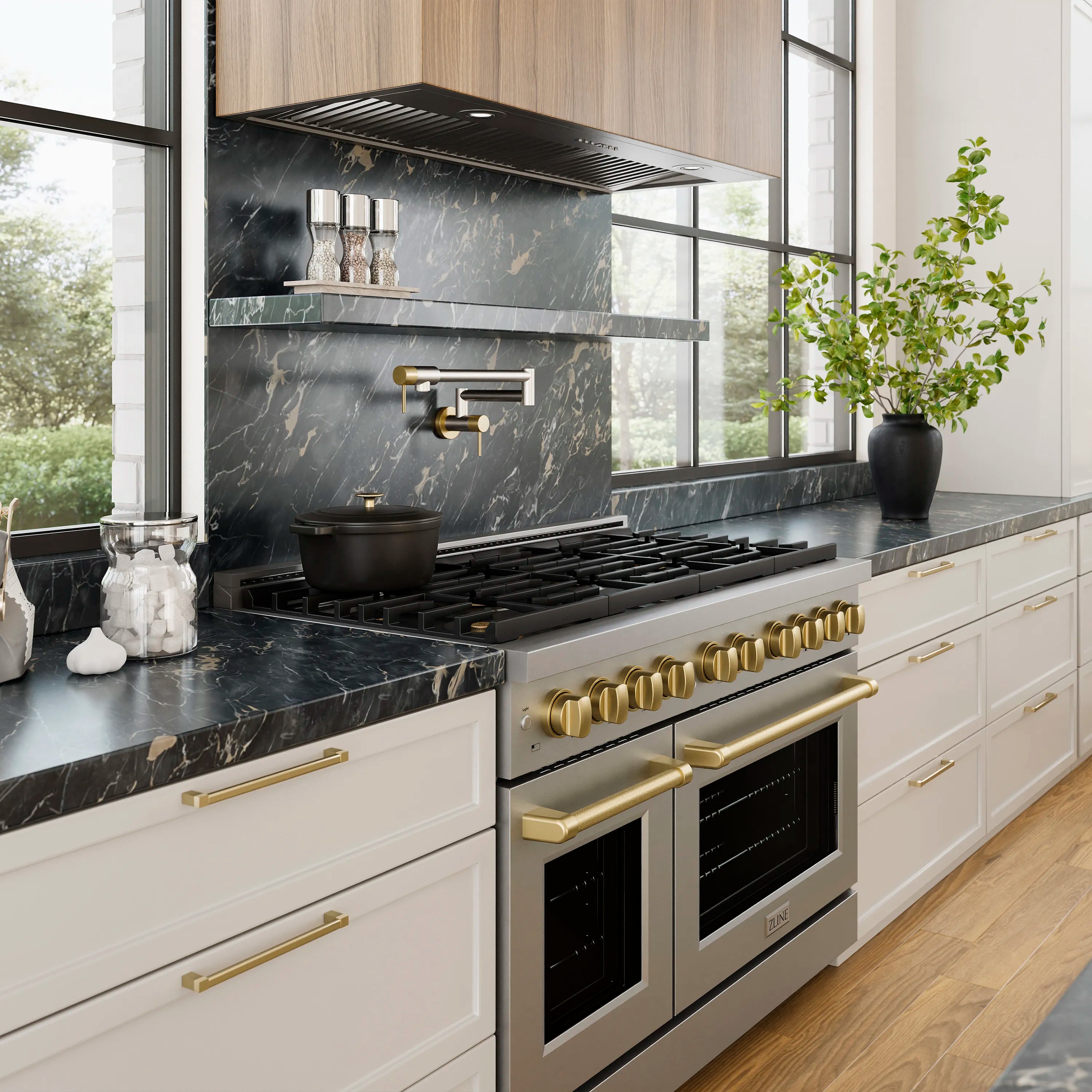 Stainless steel wall hood insert over gas cooktop with gold control trim