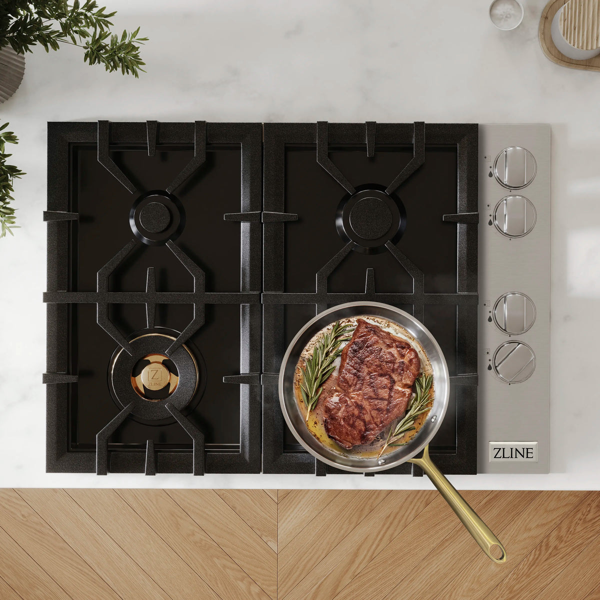 Black four-burner gas cooktop with cast grates, knobs on right, skillet on burner