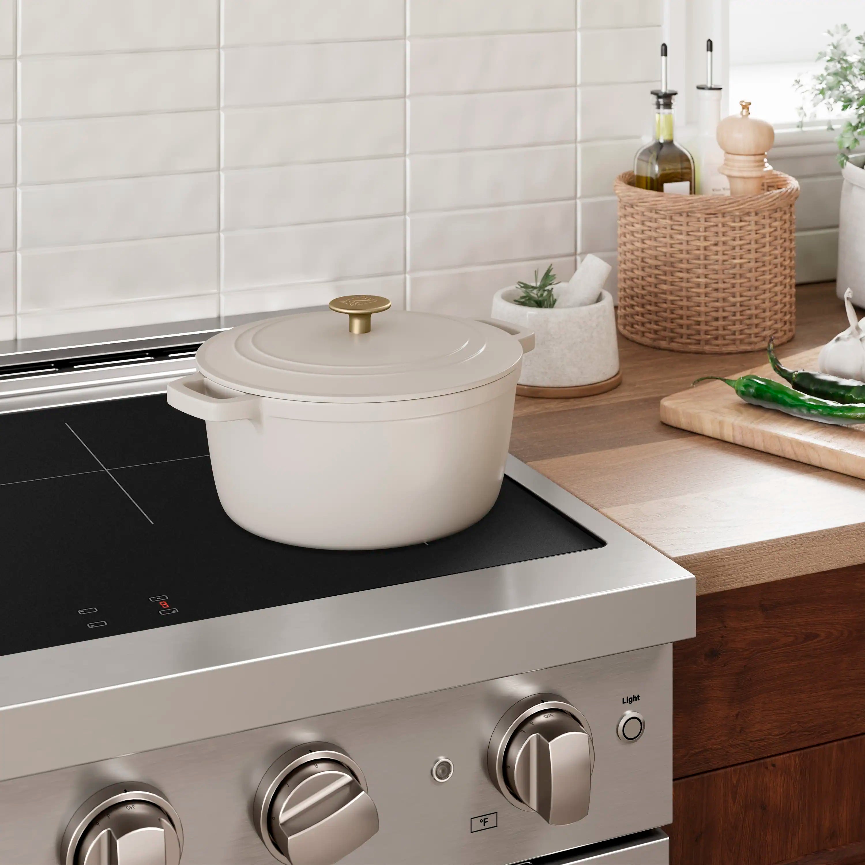 Induction cooktop with black glass surface, stainless knobs, and cooking pot