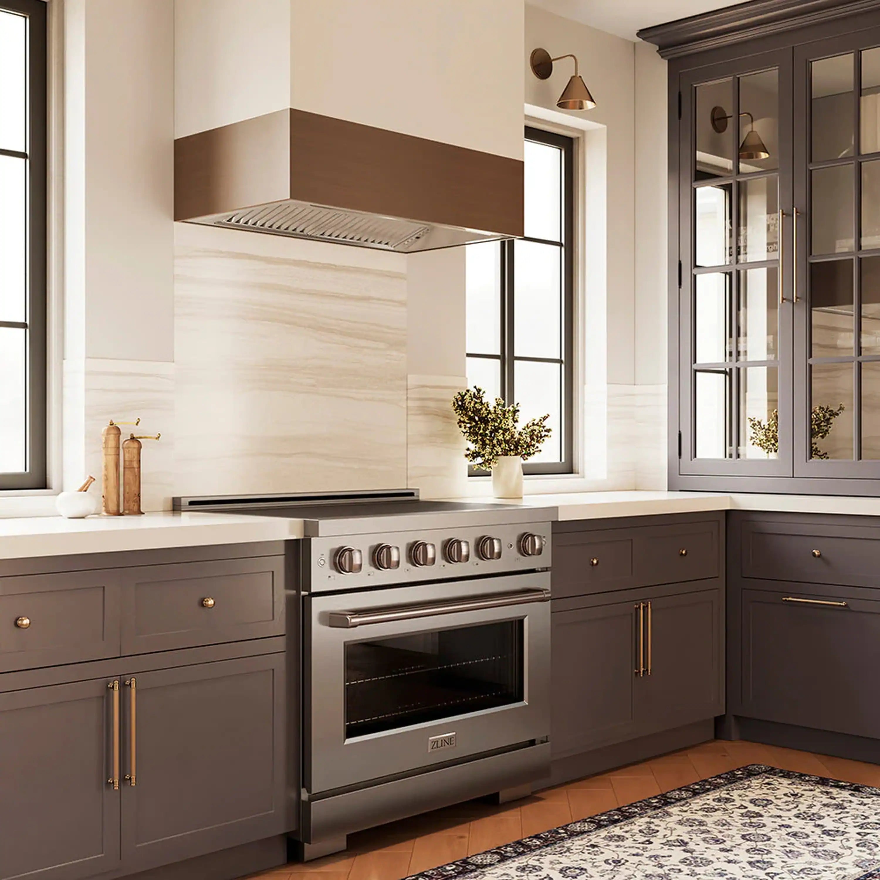 Stainless steel induction range installed in a kitchen with cabinet and hood