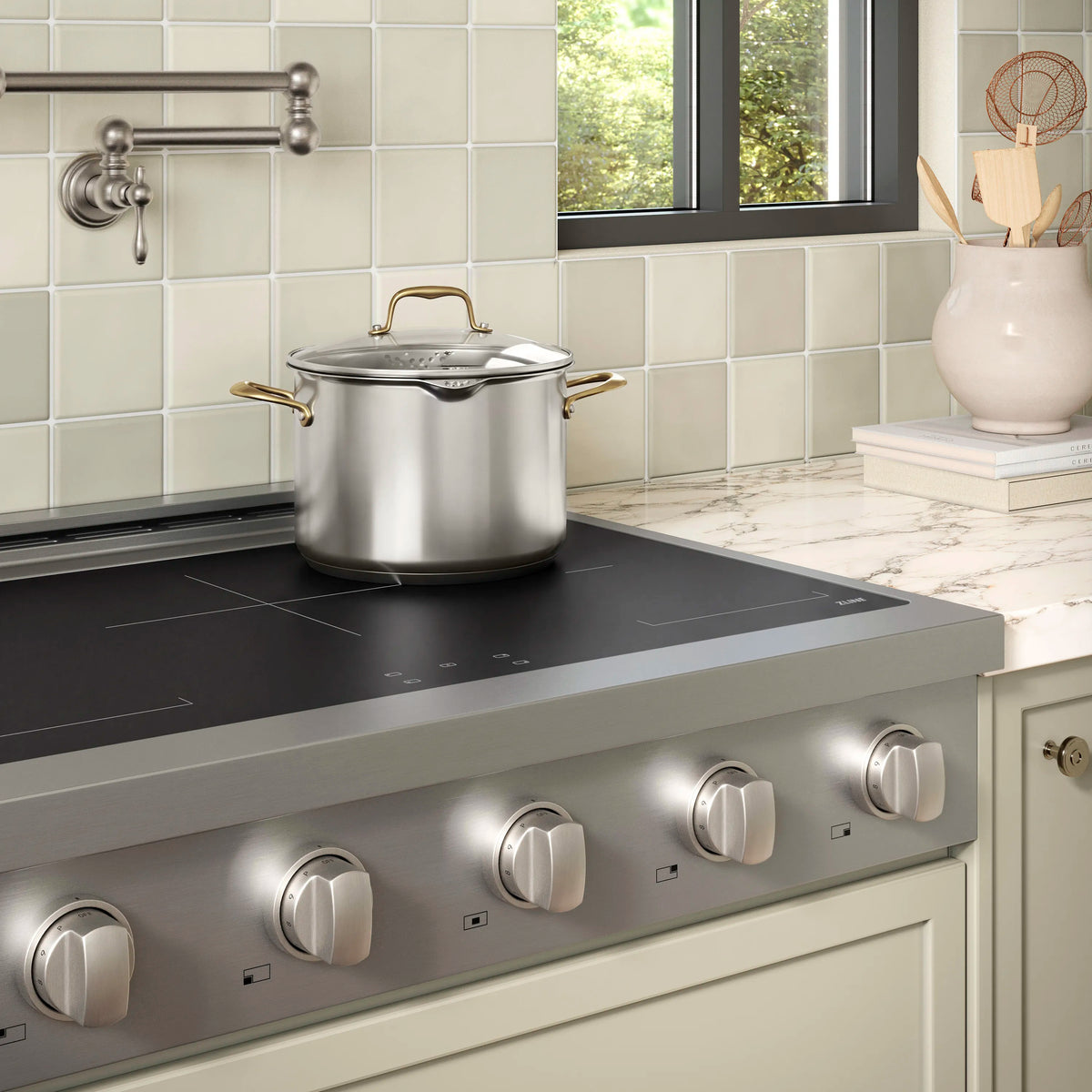 Stainless induction cooktop with black glass top and four front control knobs