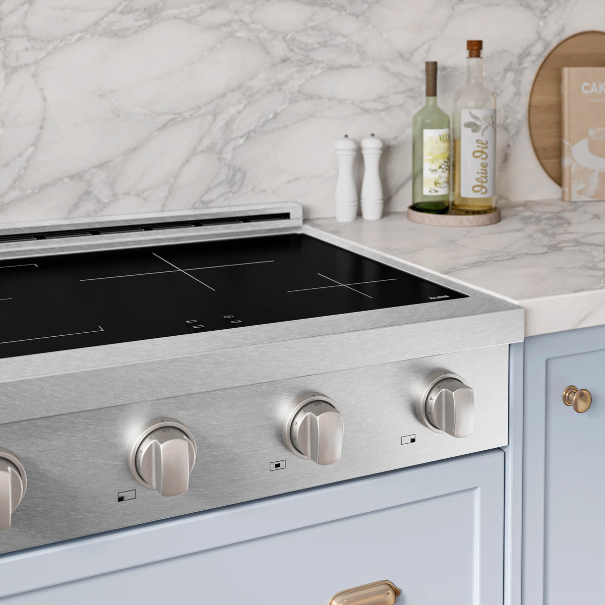 Satin stainless steel induction rangetop with four black cook zones and control knobs