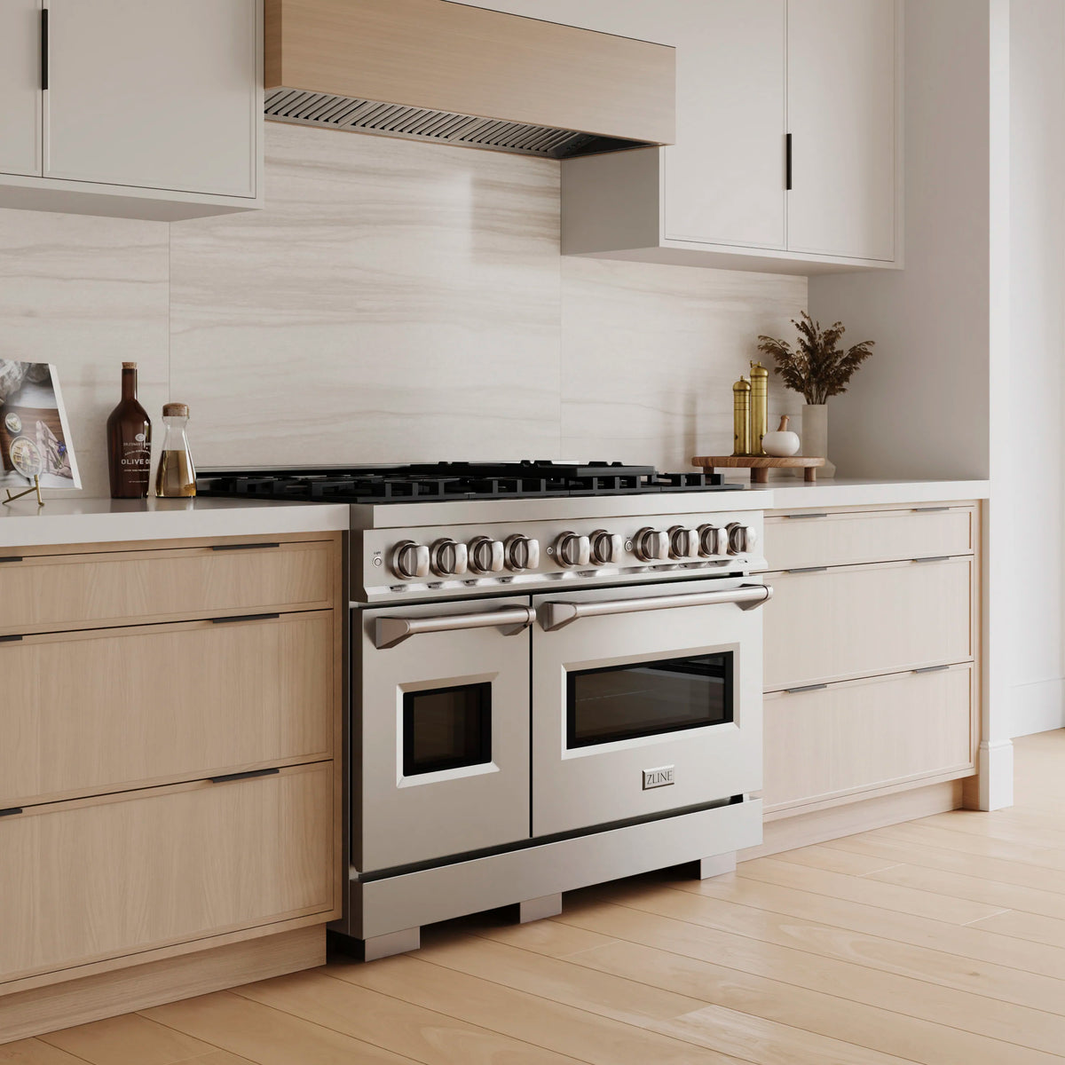 Stainless dual-oven gas range with side handles and burner knobs, front view.
