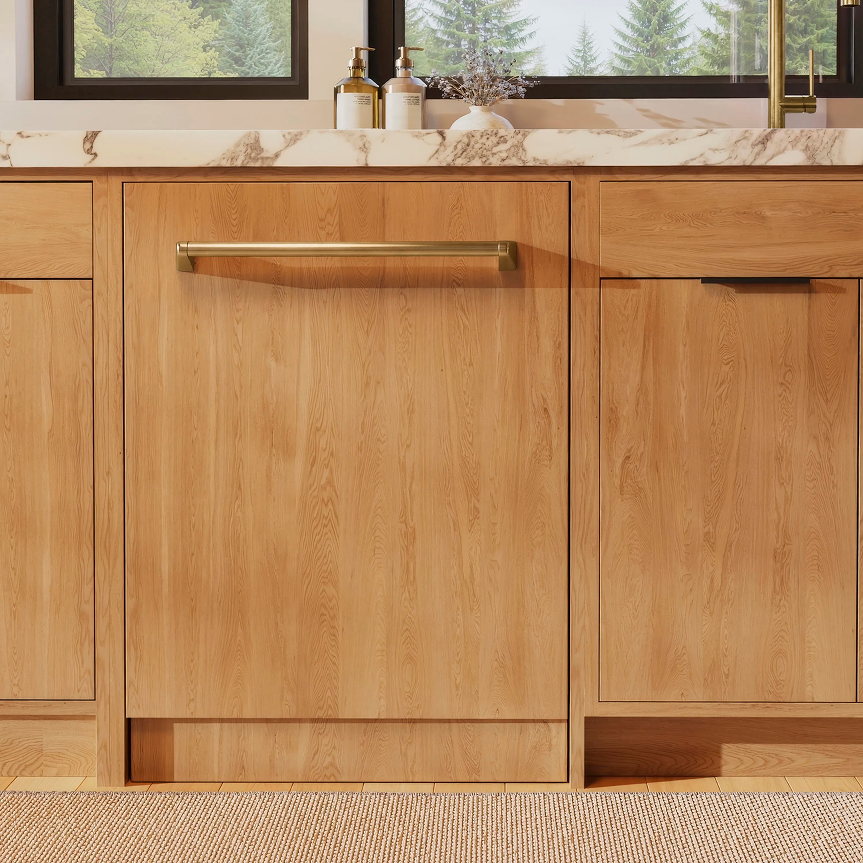 Panel-ready dishwasher with long champagne bronze handle and wood cabinetry framing