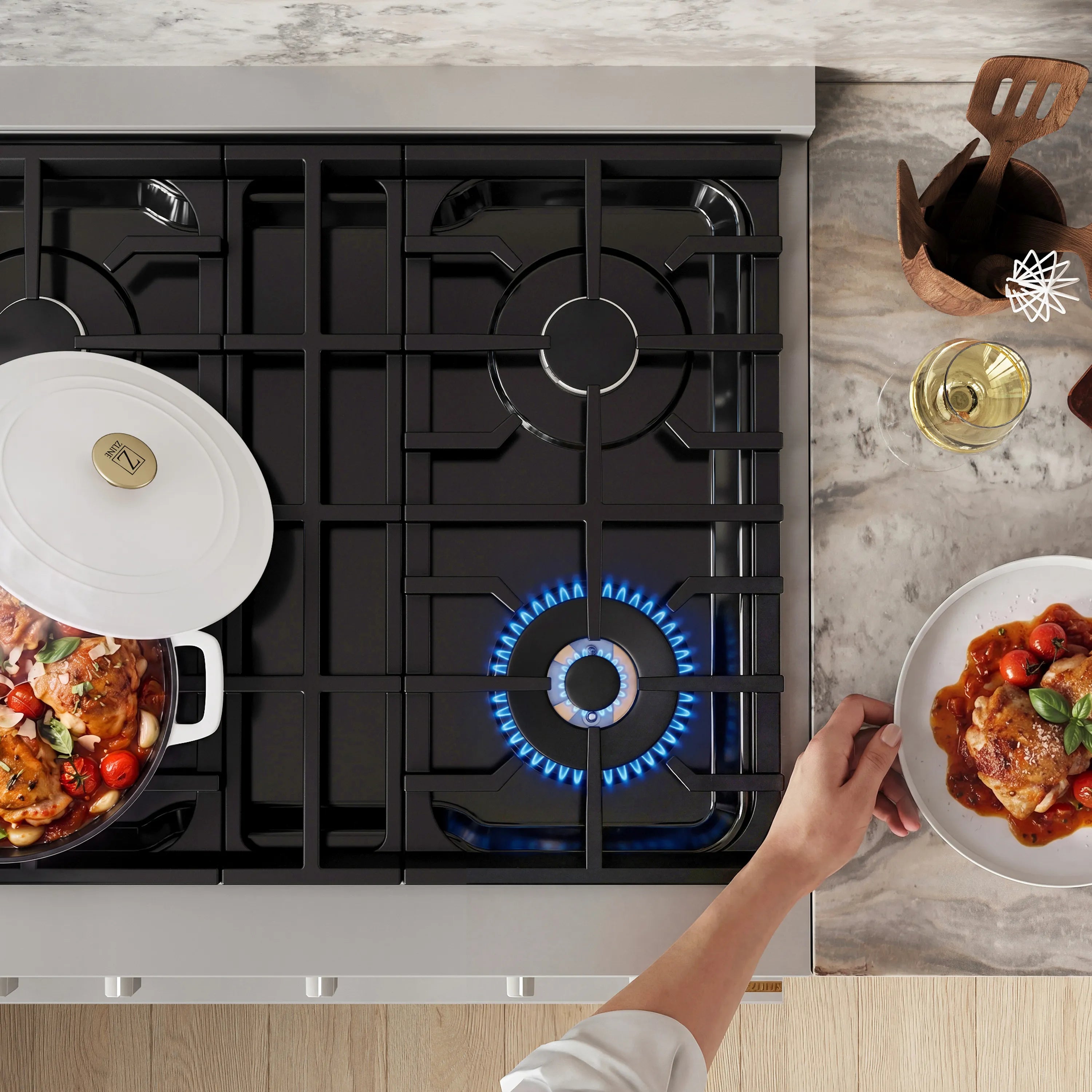 Stainless steel gas cooktop with black burner grates and two pots on burners