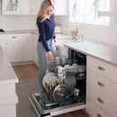 Built-in tall tub dishwasher with open door, wire racks, and dishes being loaded