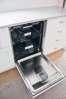 Tall built-in dishwasher door open with empty rack and stainless interior tub