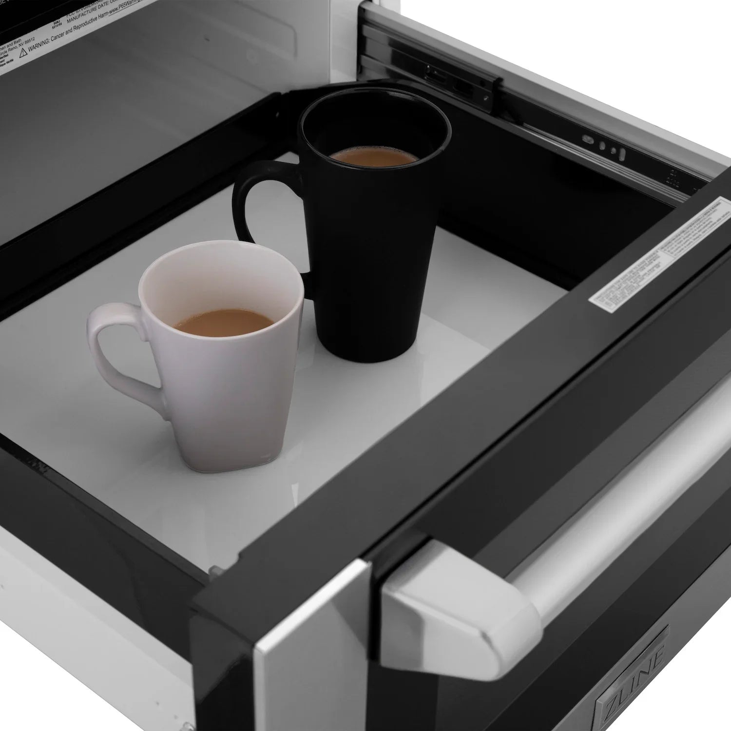 Microwave drawer with two cups and a mug on the black turntable