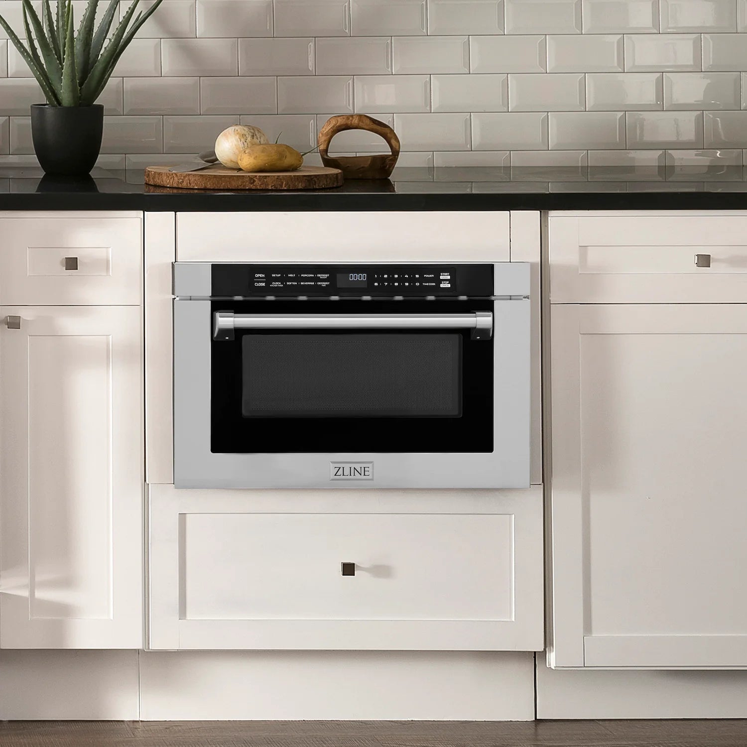 Stainless steel microwave drawer built into cabinetry with door and control panel