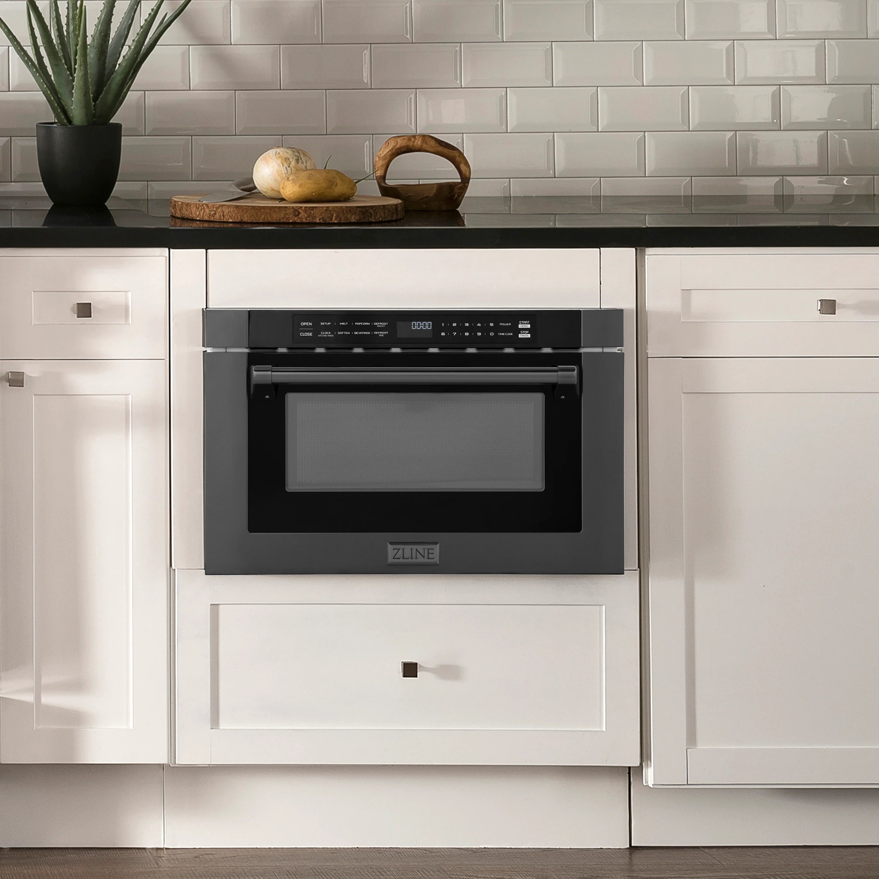Black stainless steel built-in microwave drawer installed in cabinetry with door window