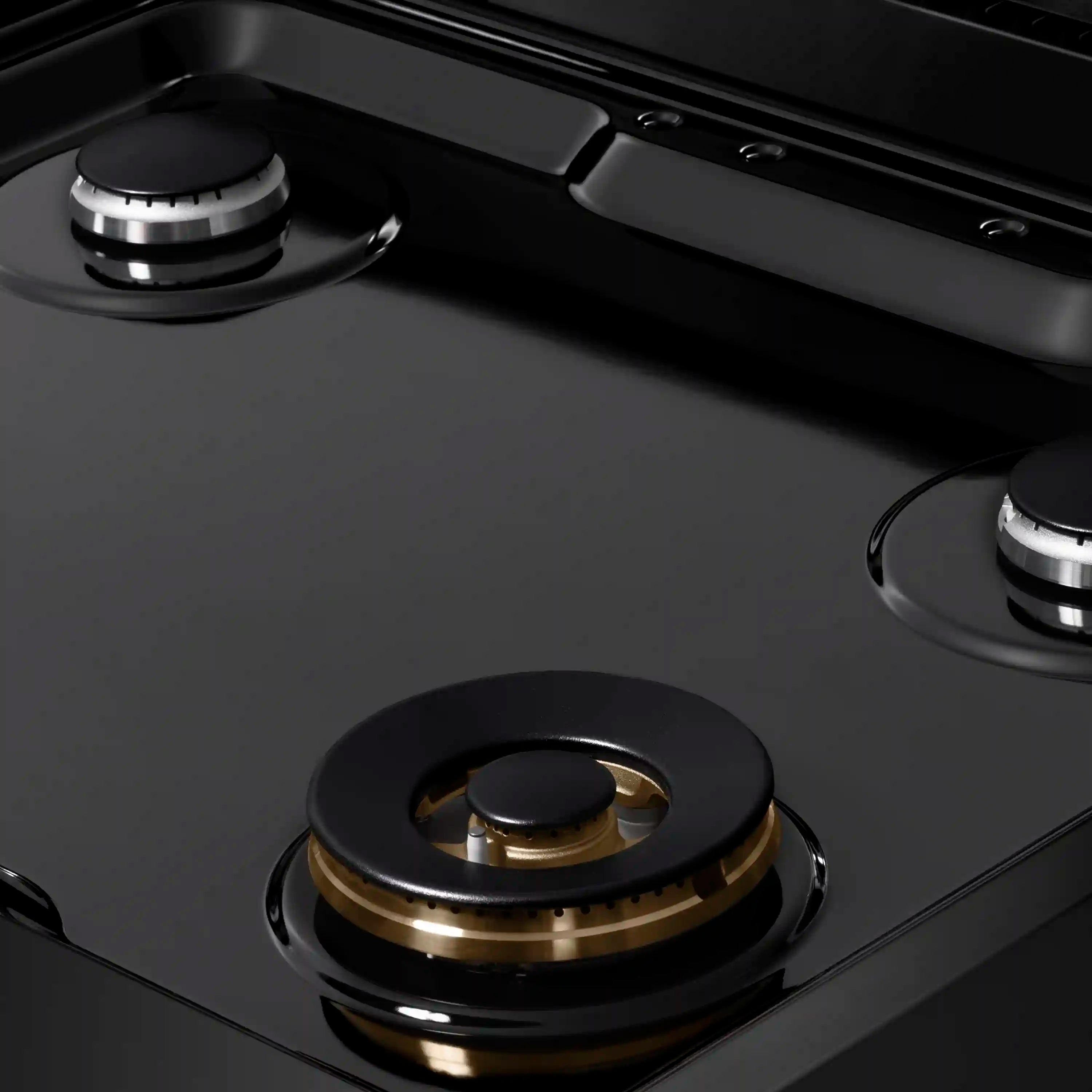 Black porcelain cooktop with gold-accent burner ring and cast-iron grate