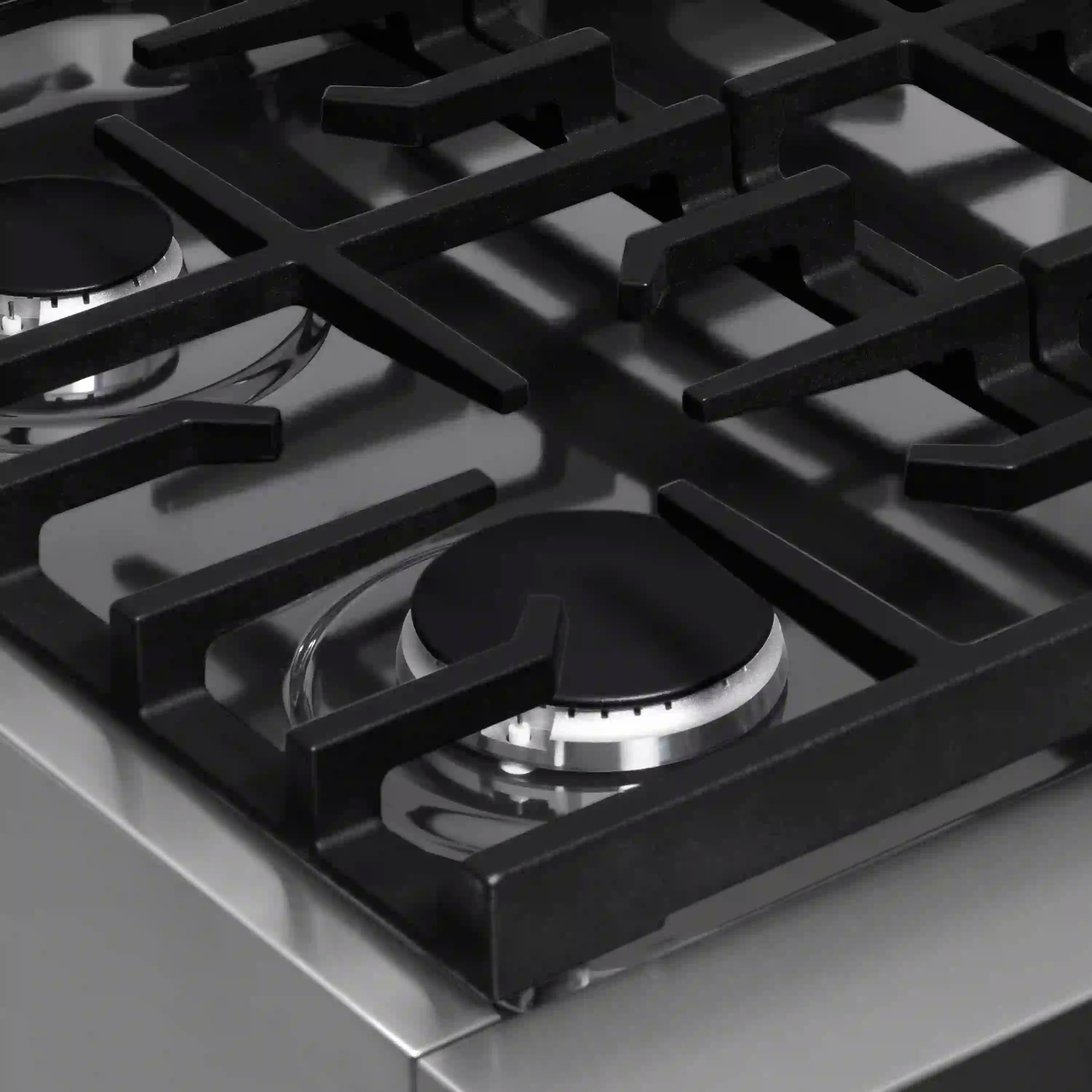 Close-up of black porcelain gas cooktop grates with a burner head and ring