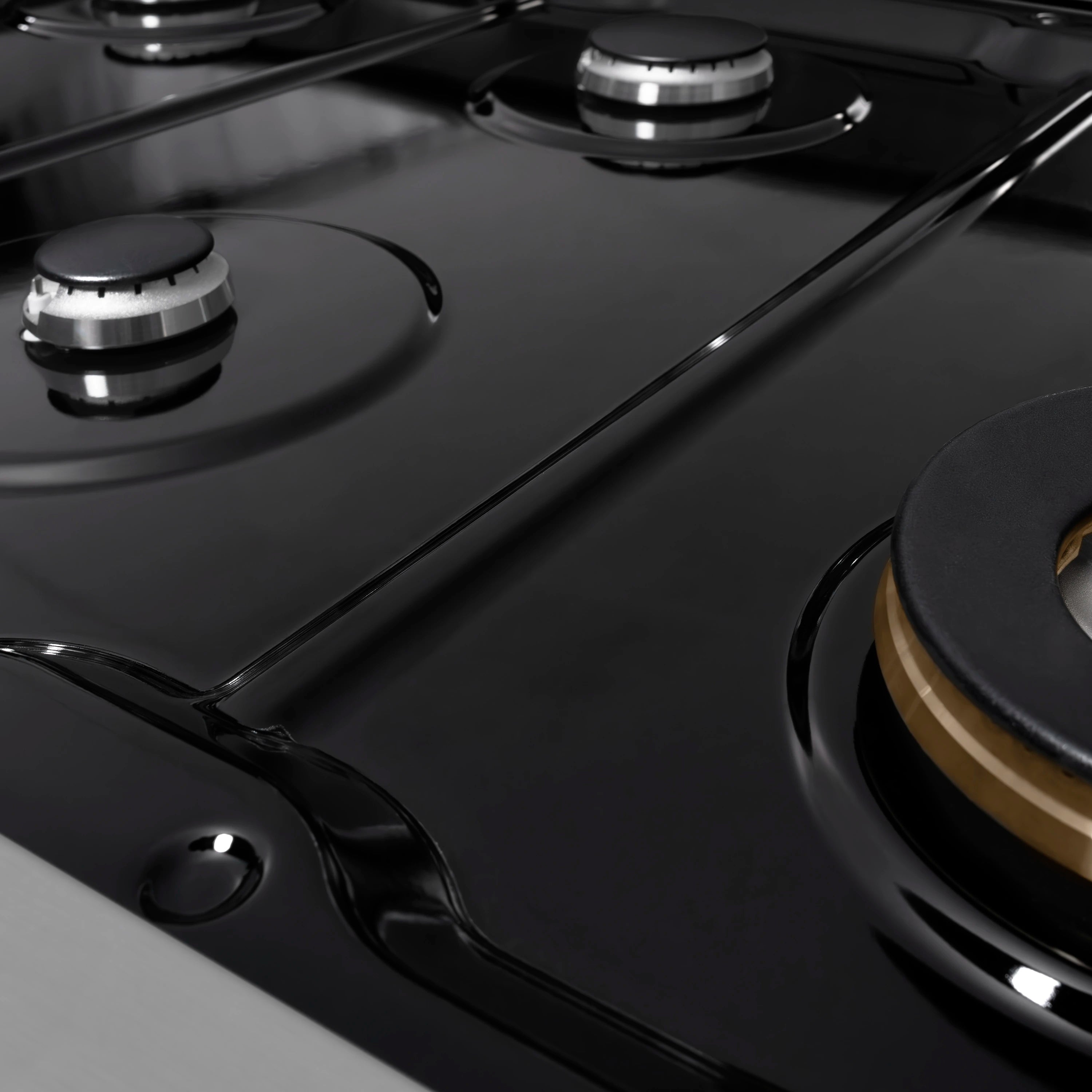 Black porcelain gas cooktop with burner rings and stainless burner grates