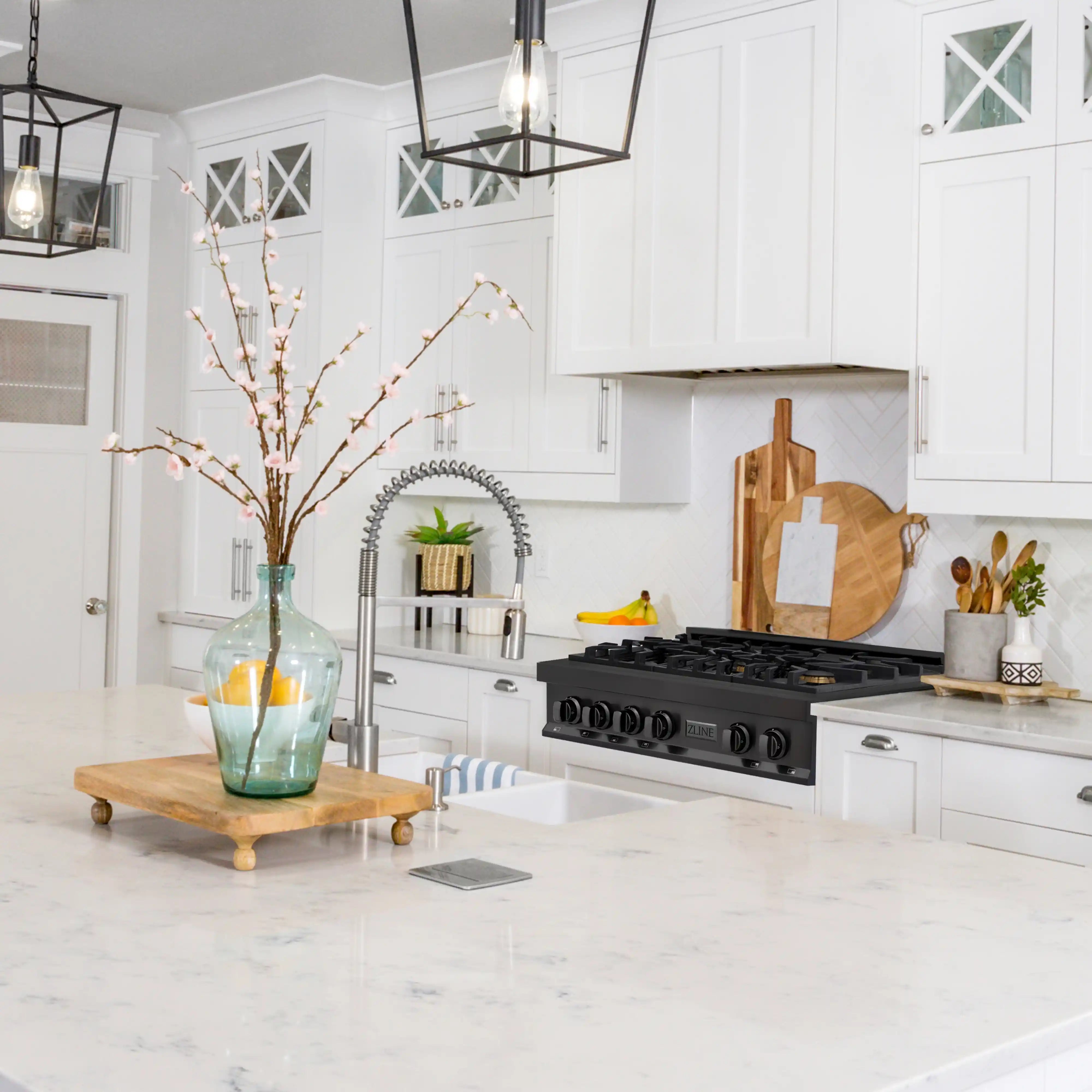Black gas rangetop with six burners in a white kitchen, showing the front control panel