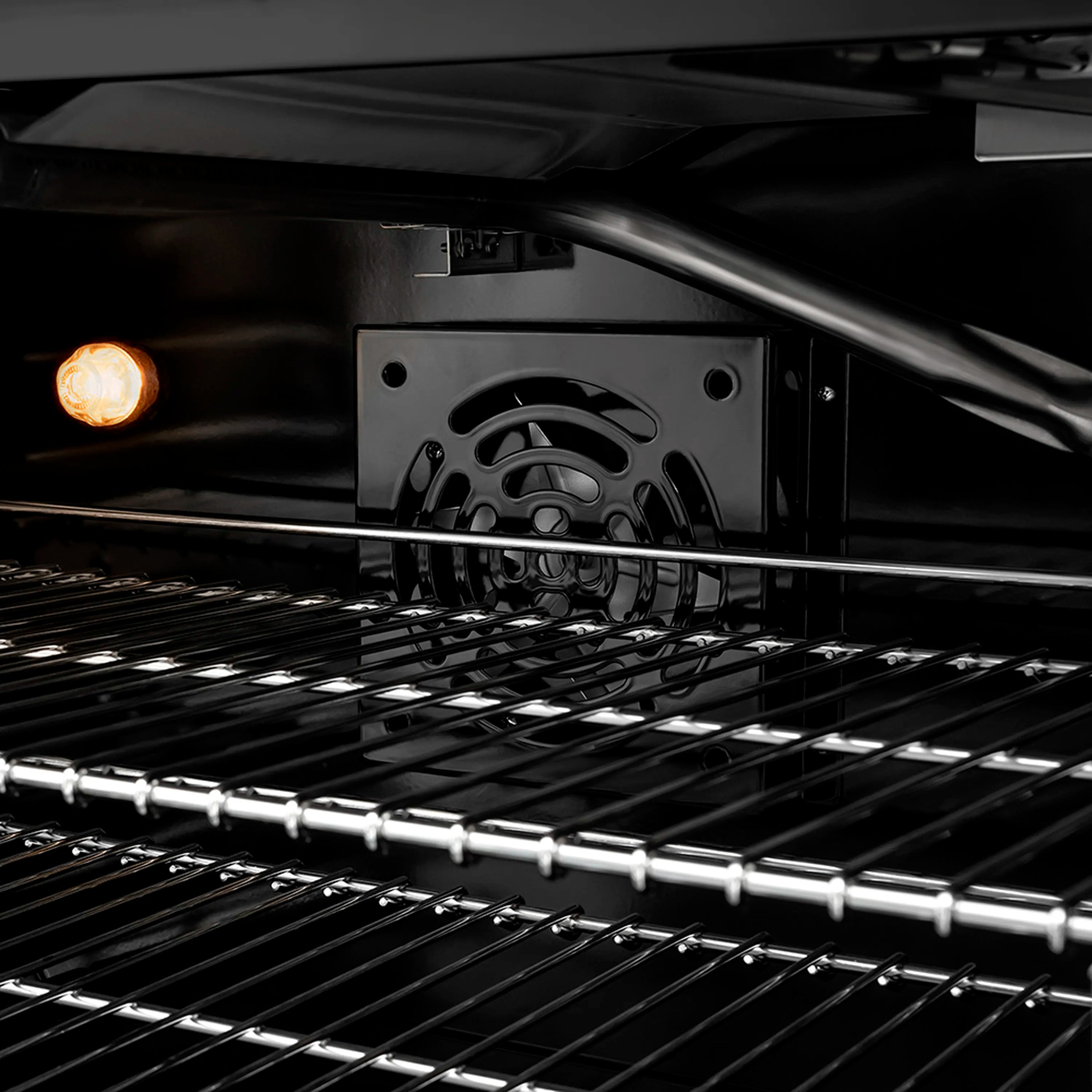 Gas oven interior with broiler element and metal cooking racks