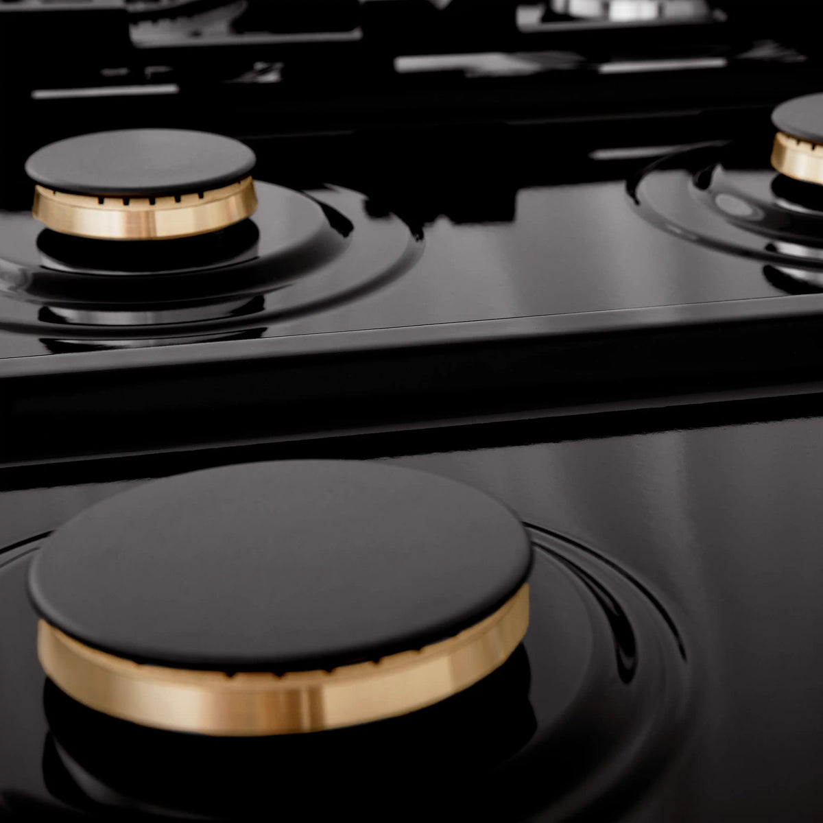 Close-up of black gas cooktop burner caps with grates and surrounding controls