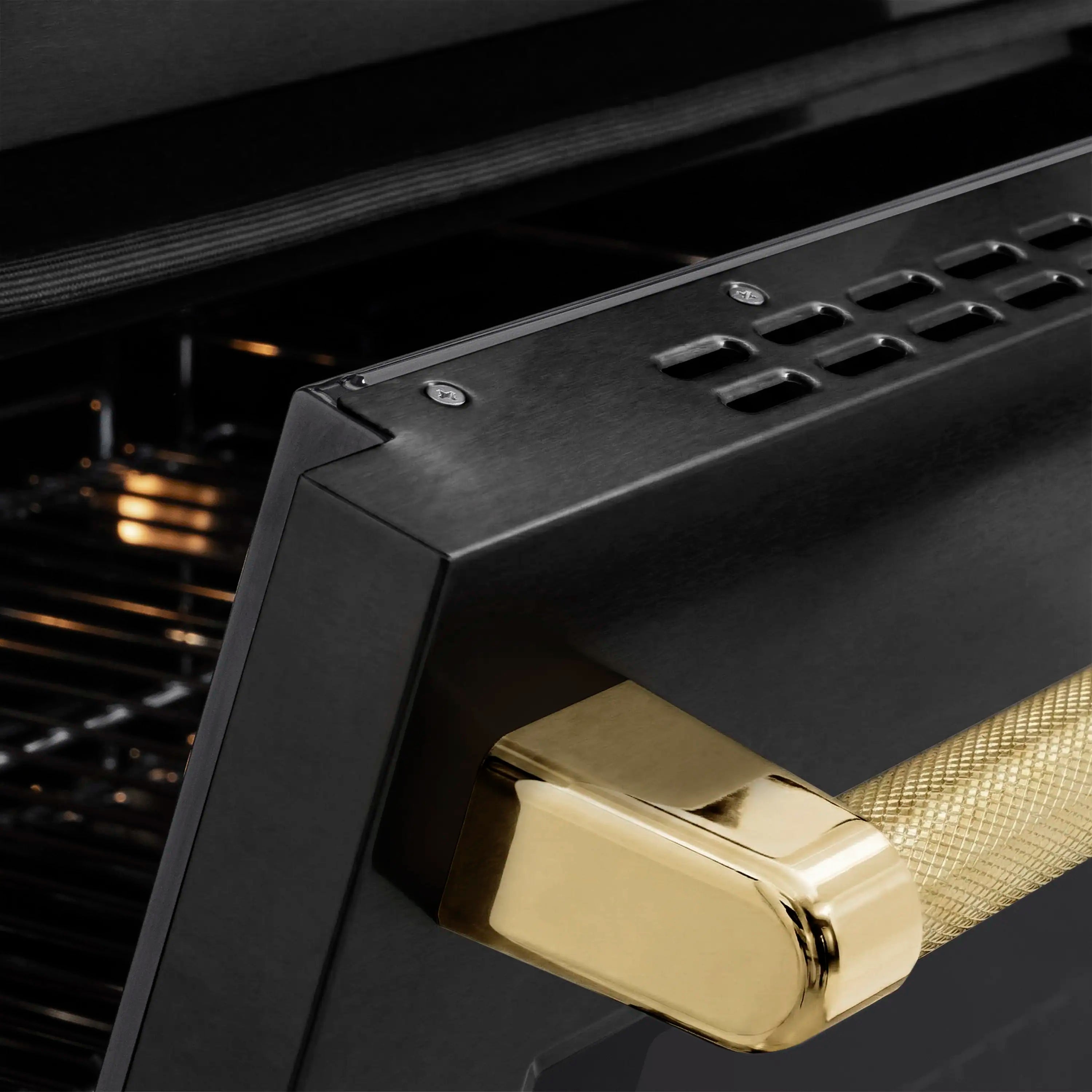 Black induction range oven door with polished gold helix handle