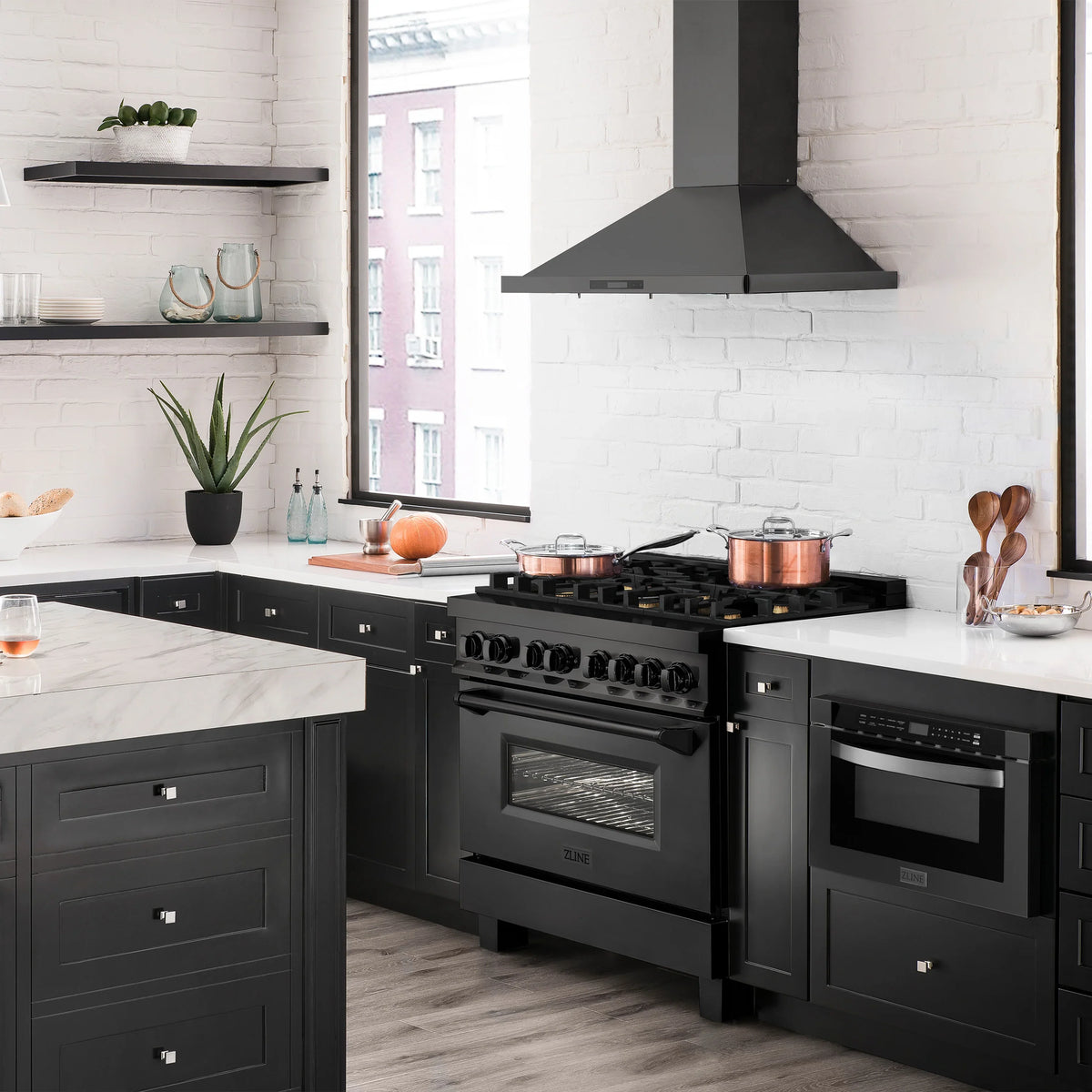 Black dual fuel range with brass burner knobs and front oven door