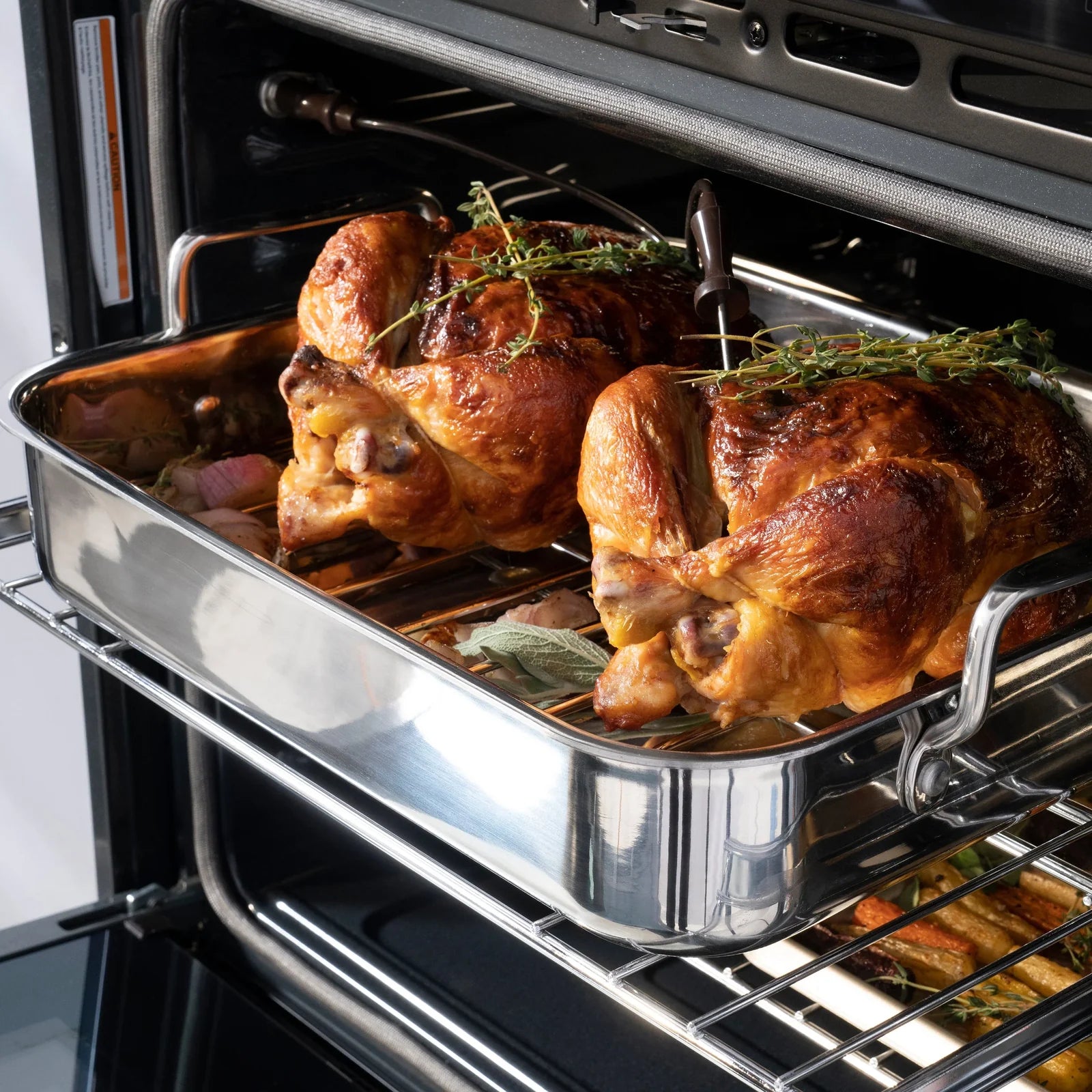 Double wall oven with roasted chicken and herbs on the rack