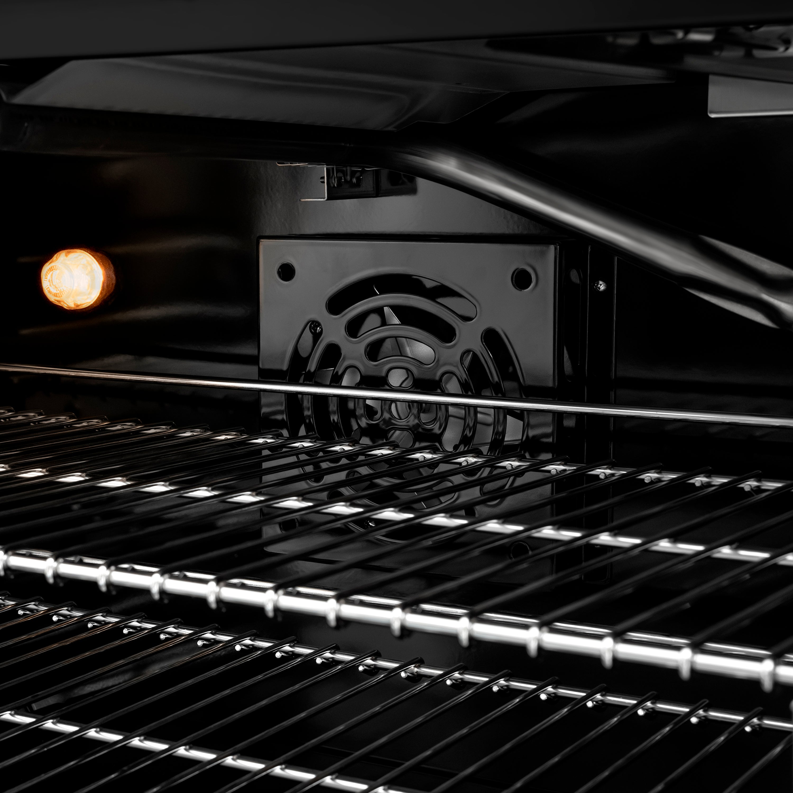 Gas oven interior with metal racks, baking light, and open door view