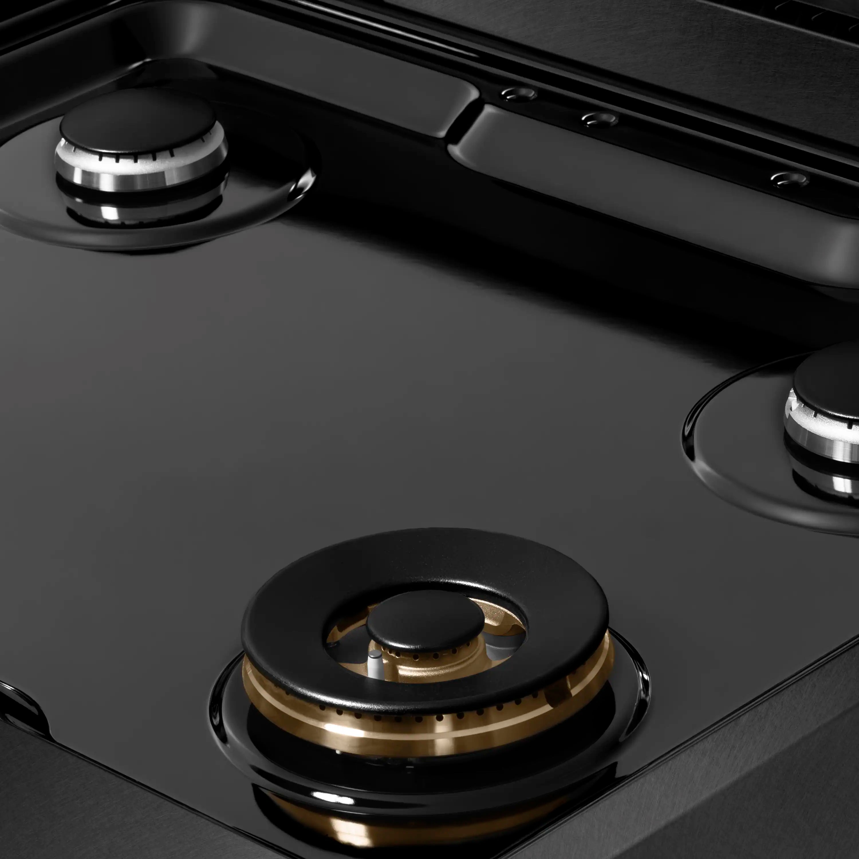 Black gas rangetop with burner caps, cast grates, and control knobs along the rail