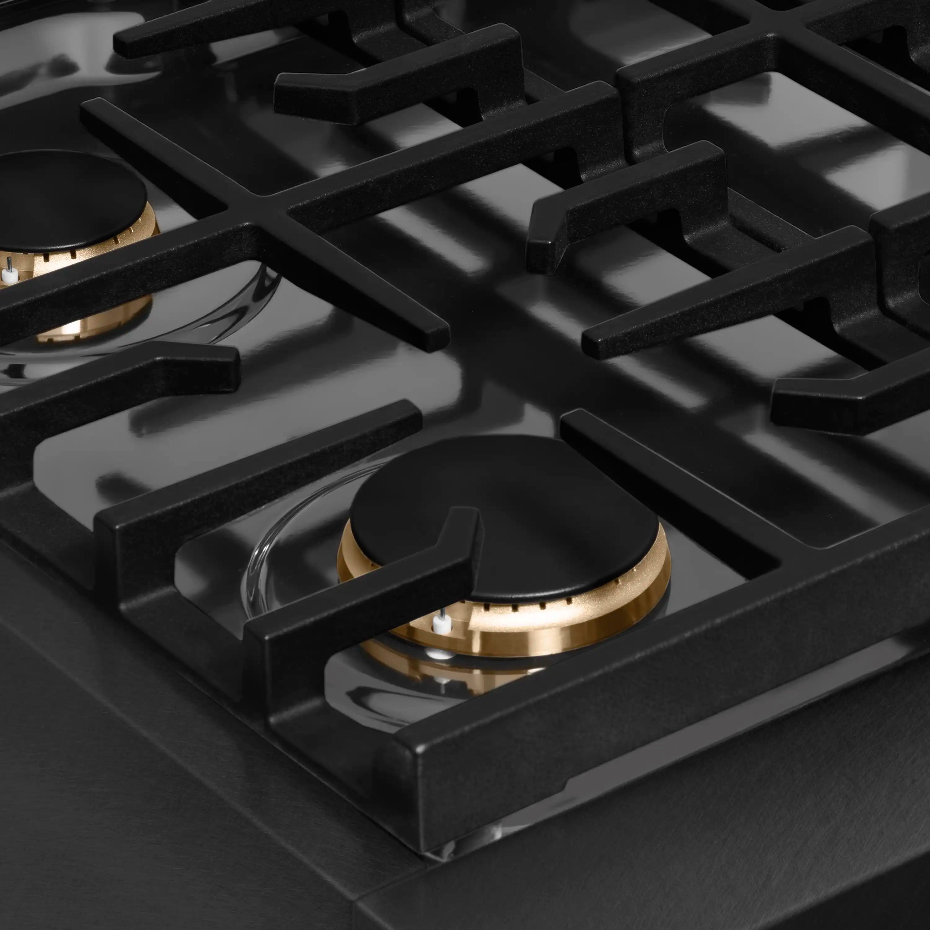 Close-up of black grate over a front burner with champagne bronze flame ring