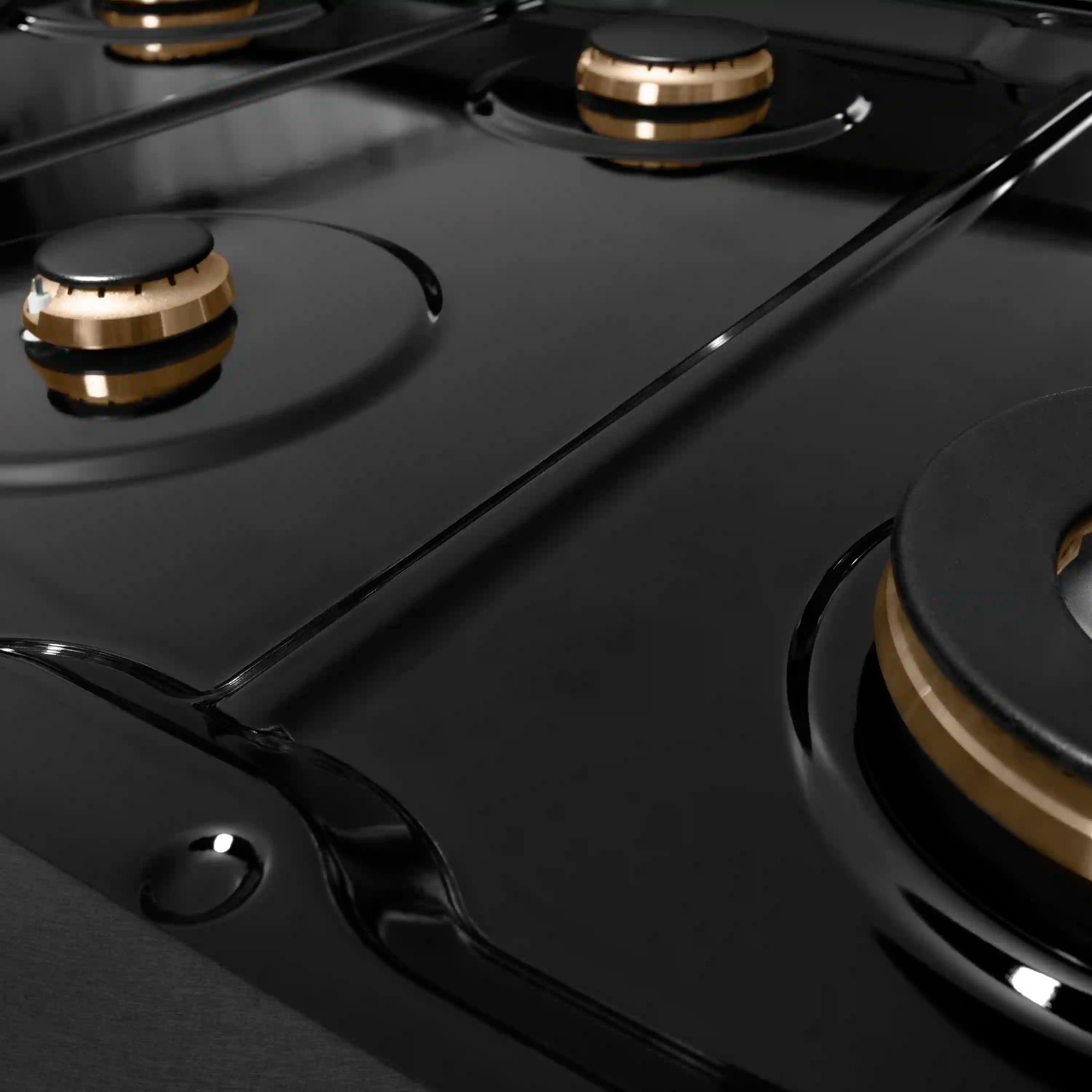 Black gas cooktop with knobs and champagne-accented burner rings