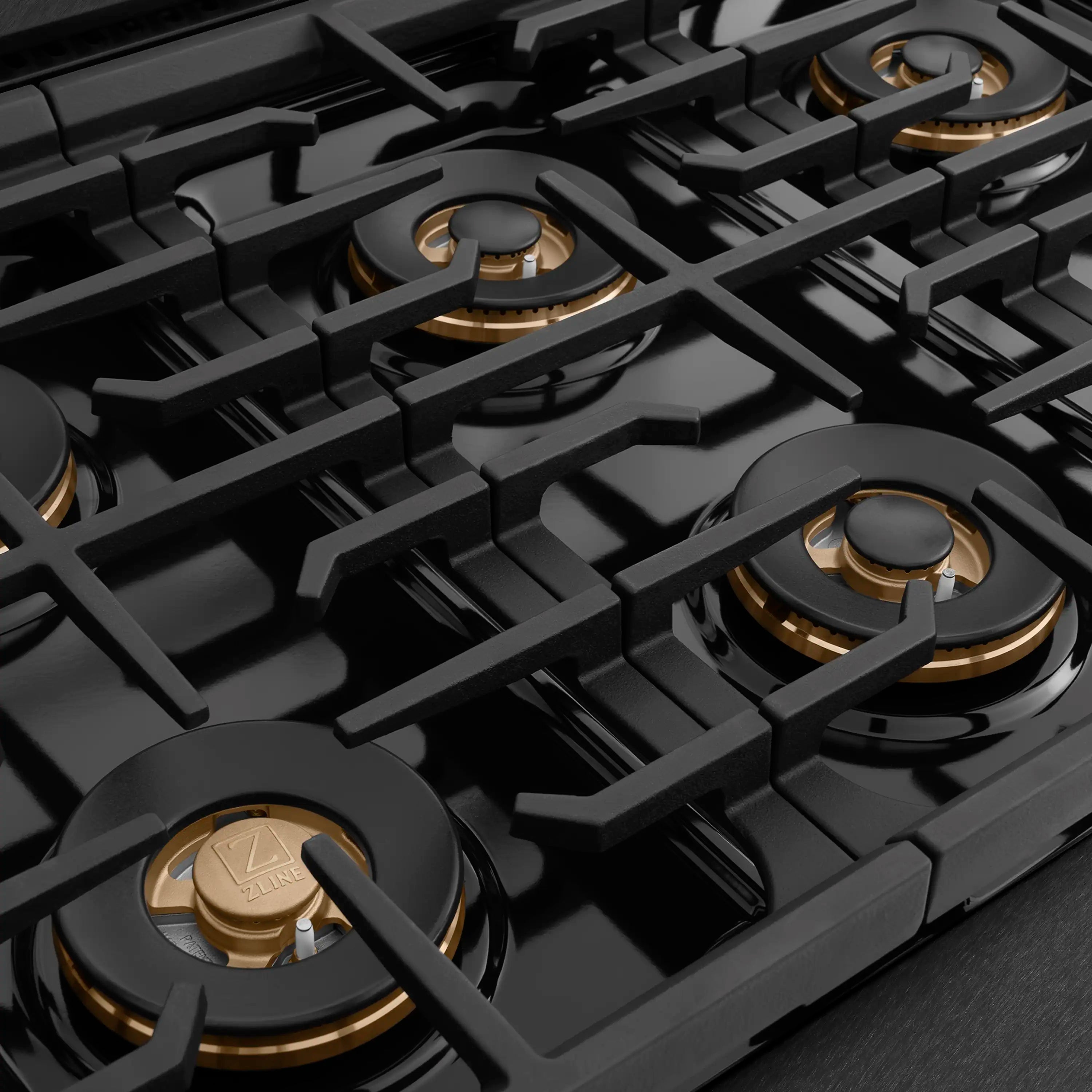 Six black gas burners with brass accents and cast-iron grate sections