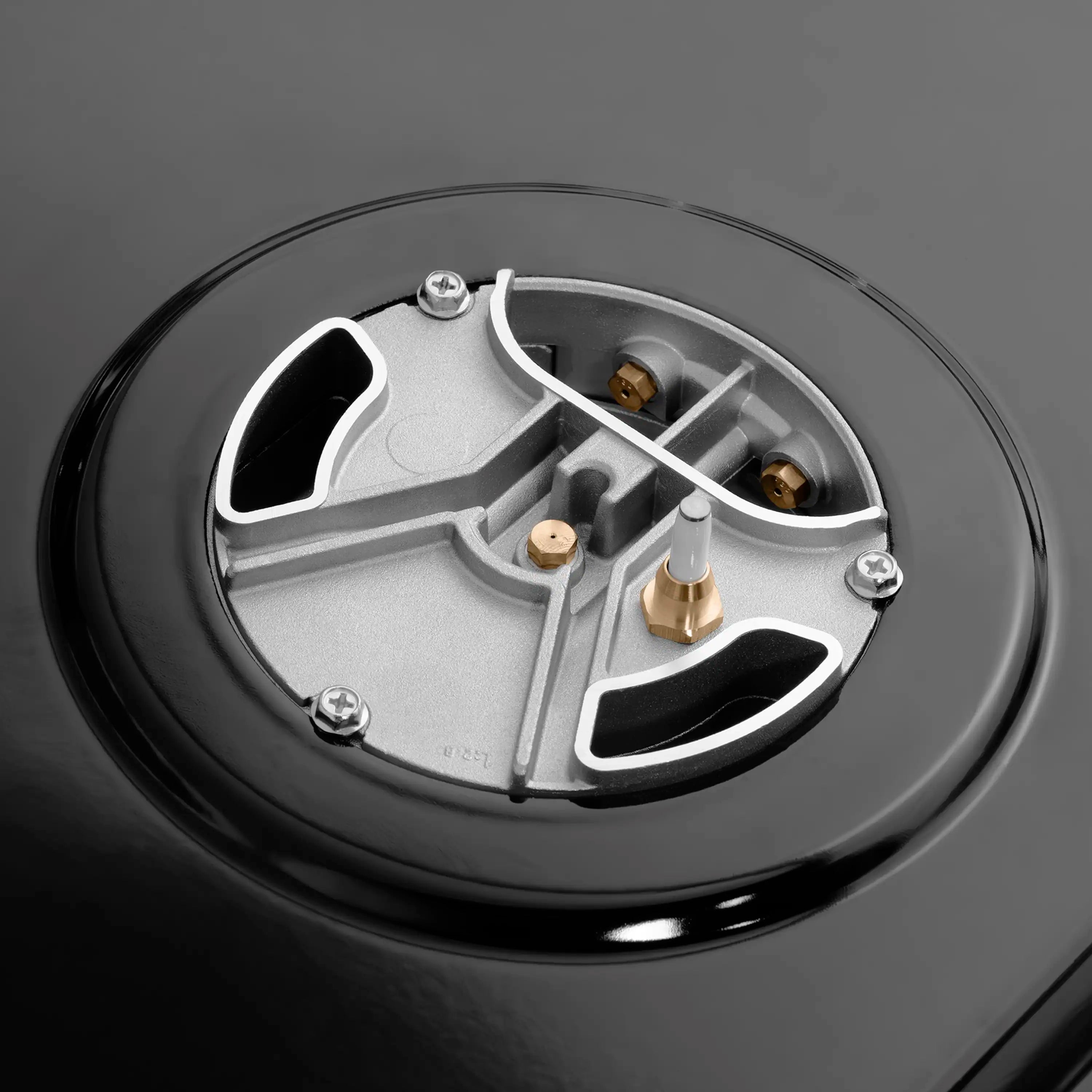 Black gas cooktop burner with champagne brass cap and stainless grates