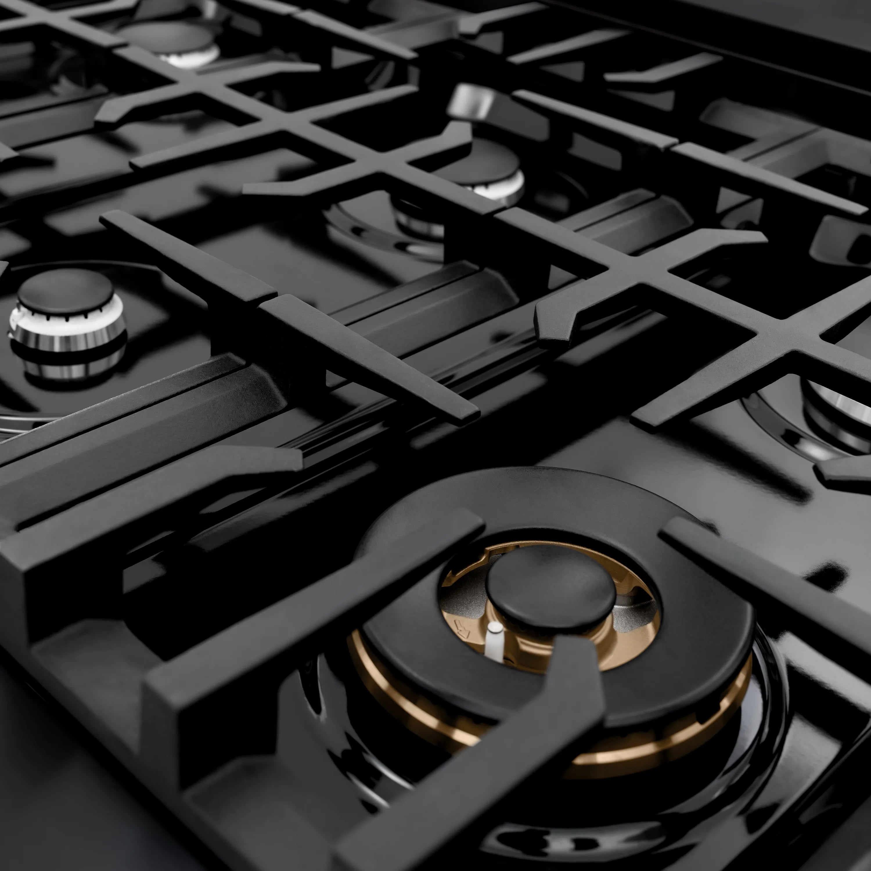 Black gas cooktop with burner grates and a center burner showing valve details