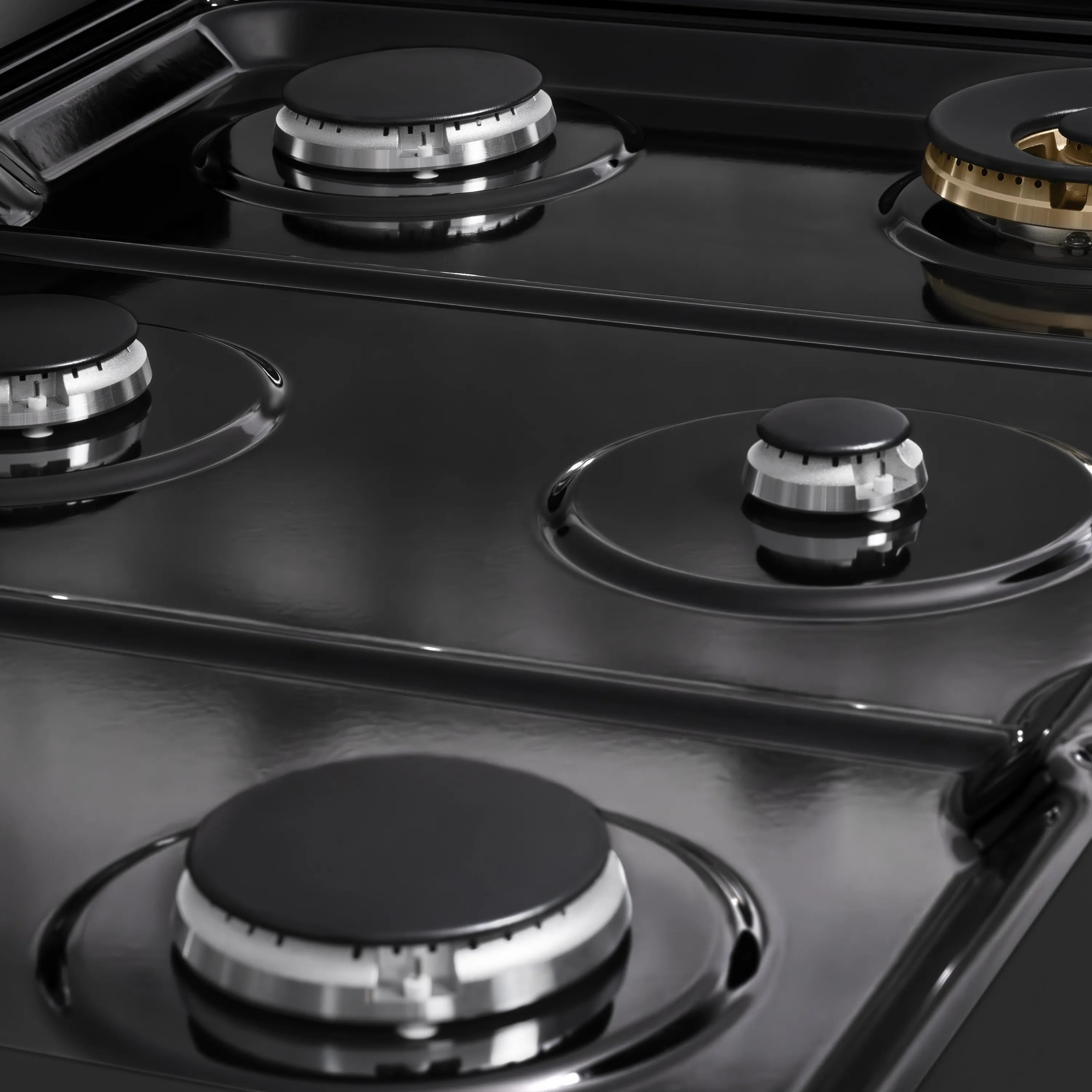 Black gas cooktop surface with four burner grates and control knobs
