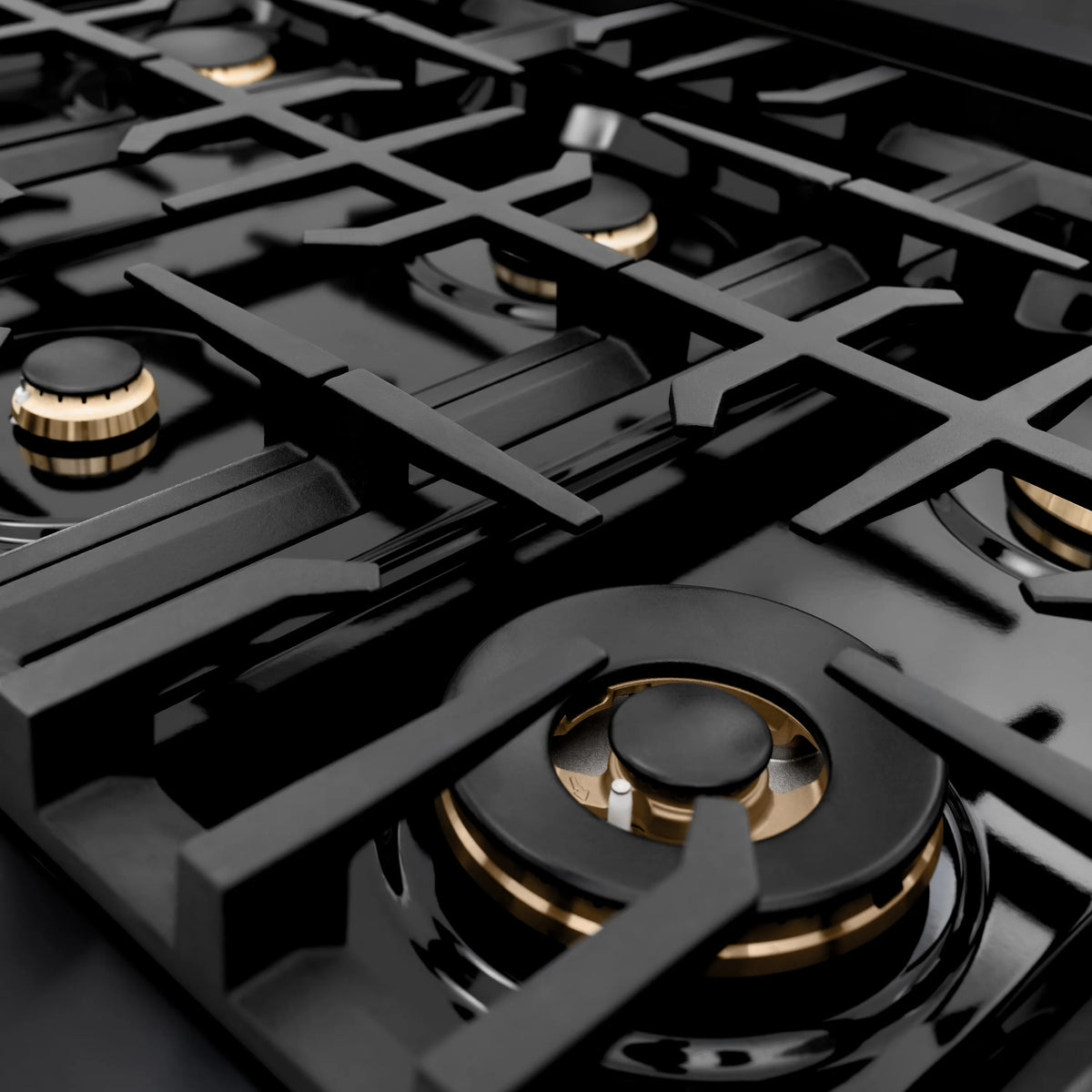 Gas rangetop burner cap with black top and champagne bronze ring accents