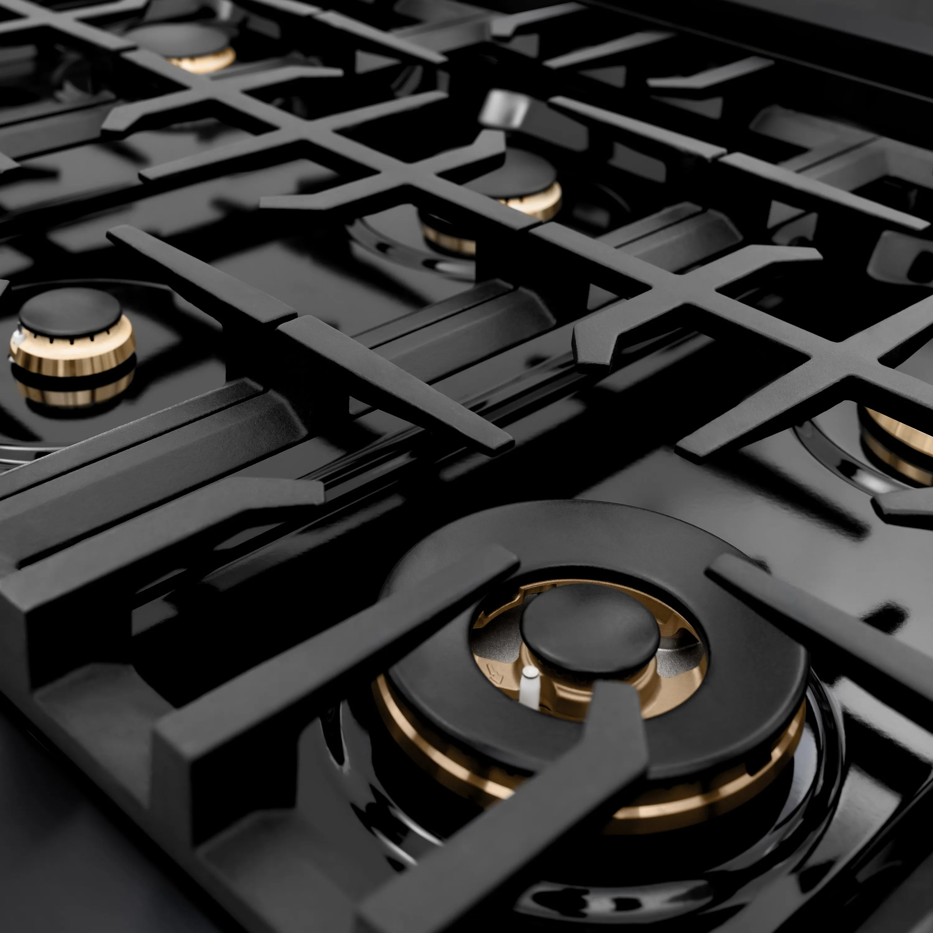 Gas rangetop with multiple black burners and gold accents on grates