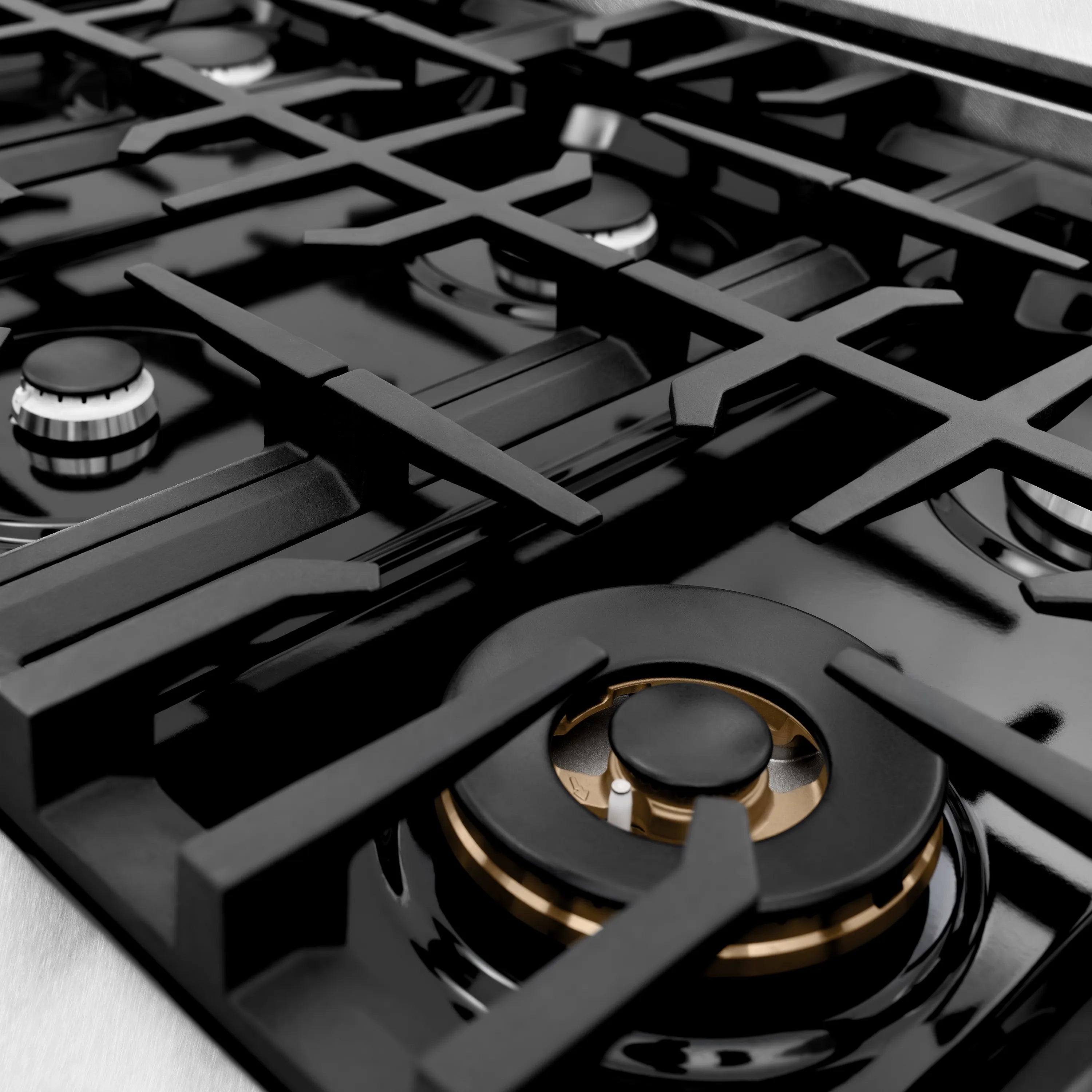 Stainless gas stovetop with black grates and burner caps, top view