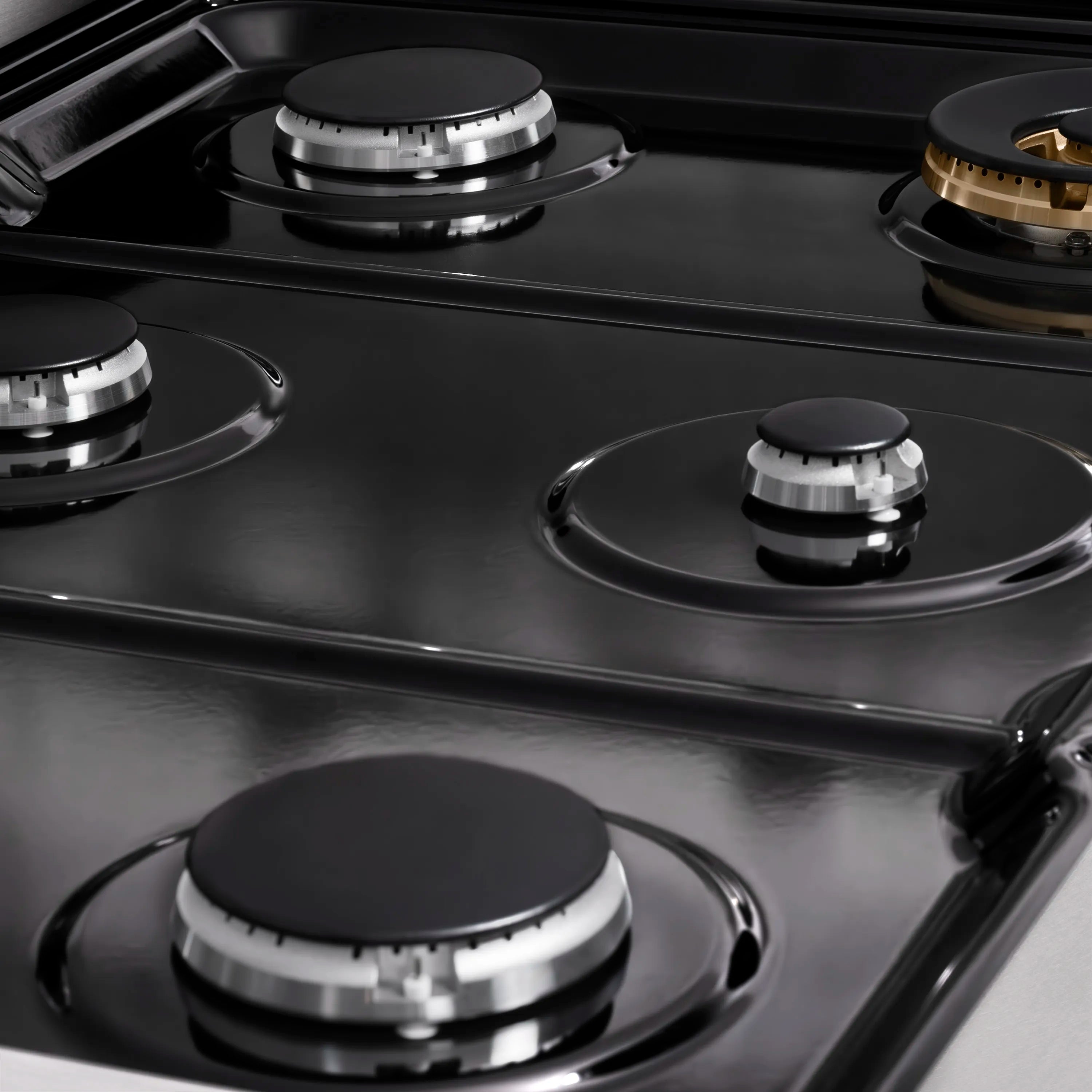 Gas stovetop cooktop with four black burner caps and round grate rings