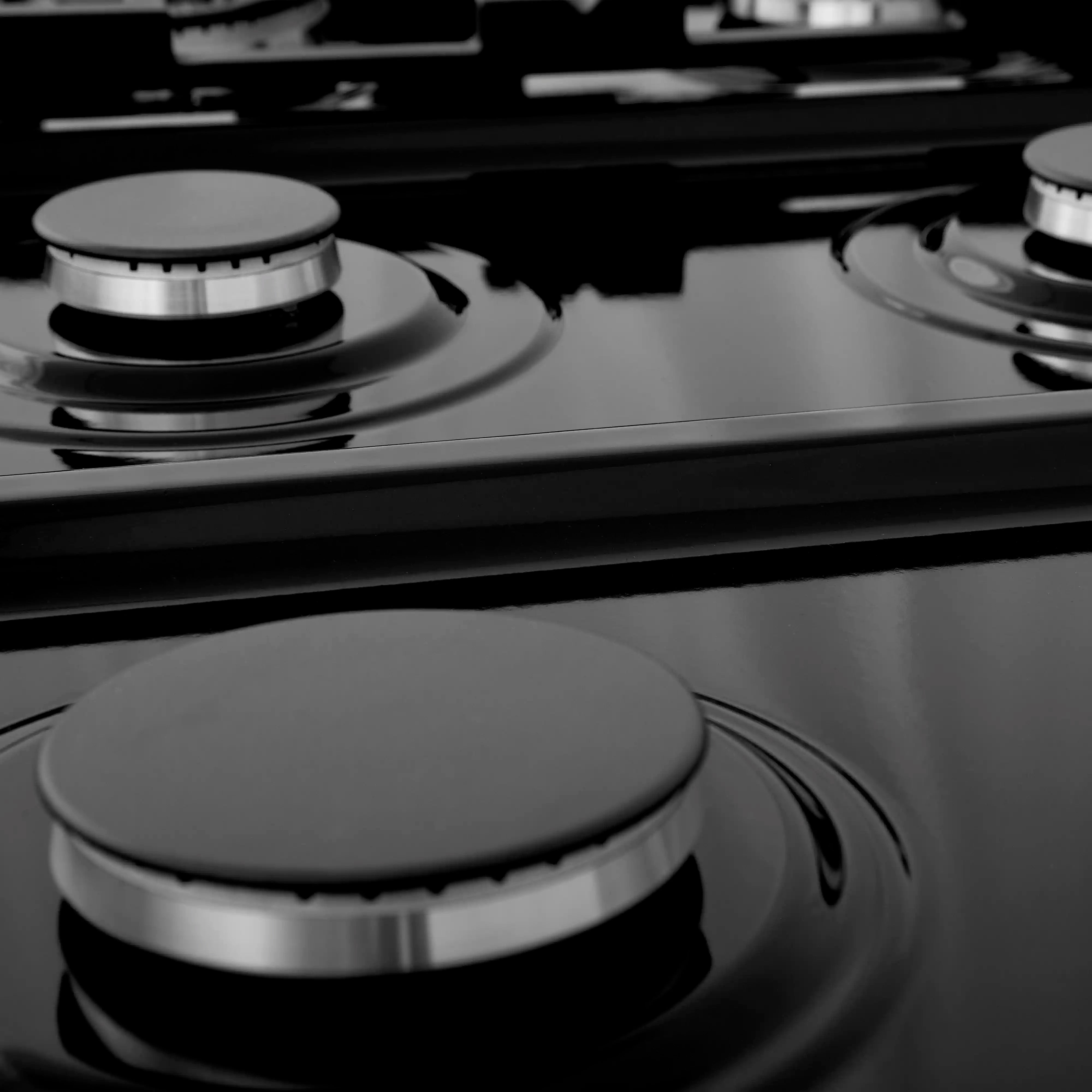 Close-up of stainless steel rangetop burner with black burner caps and control knobs