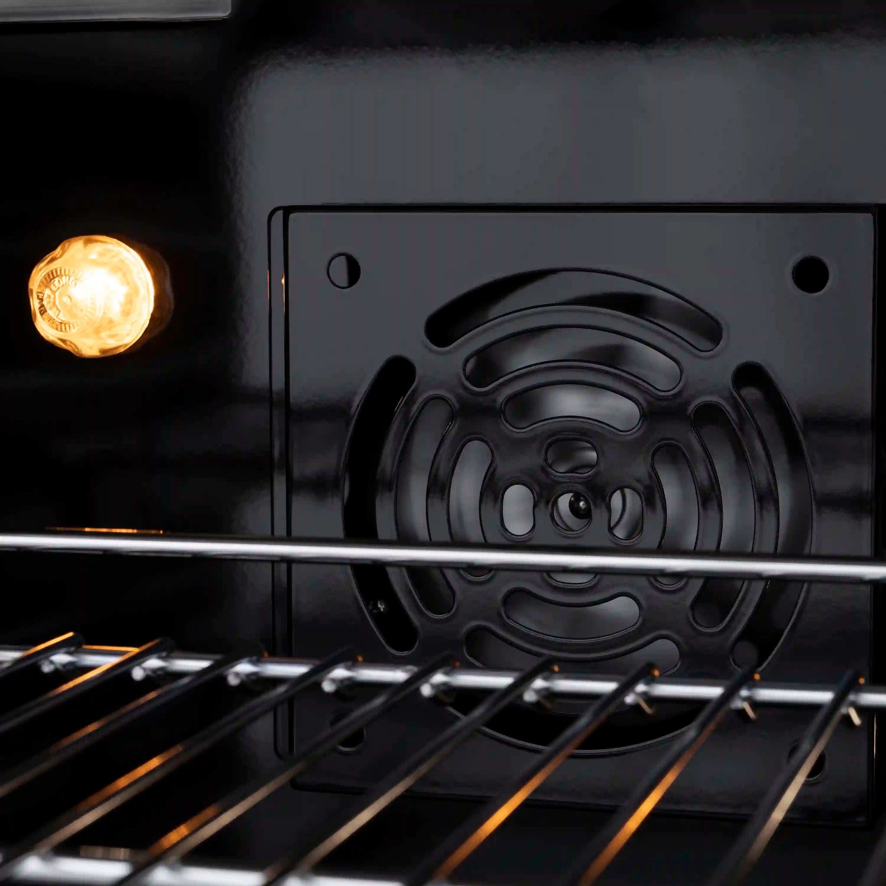 Electric convection oven interior with bake light and wire oven racks